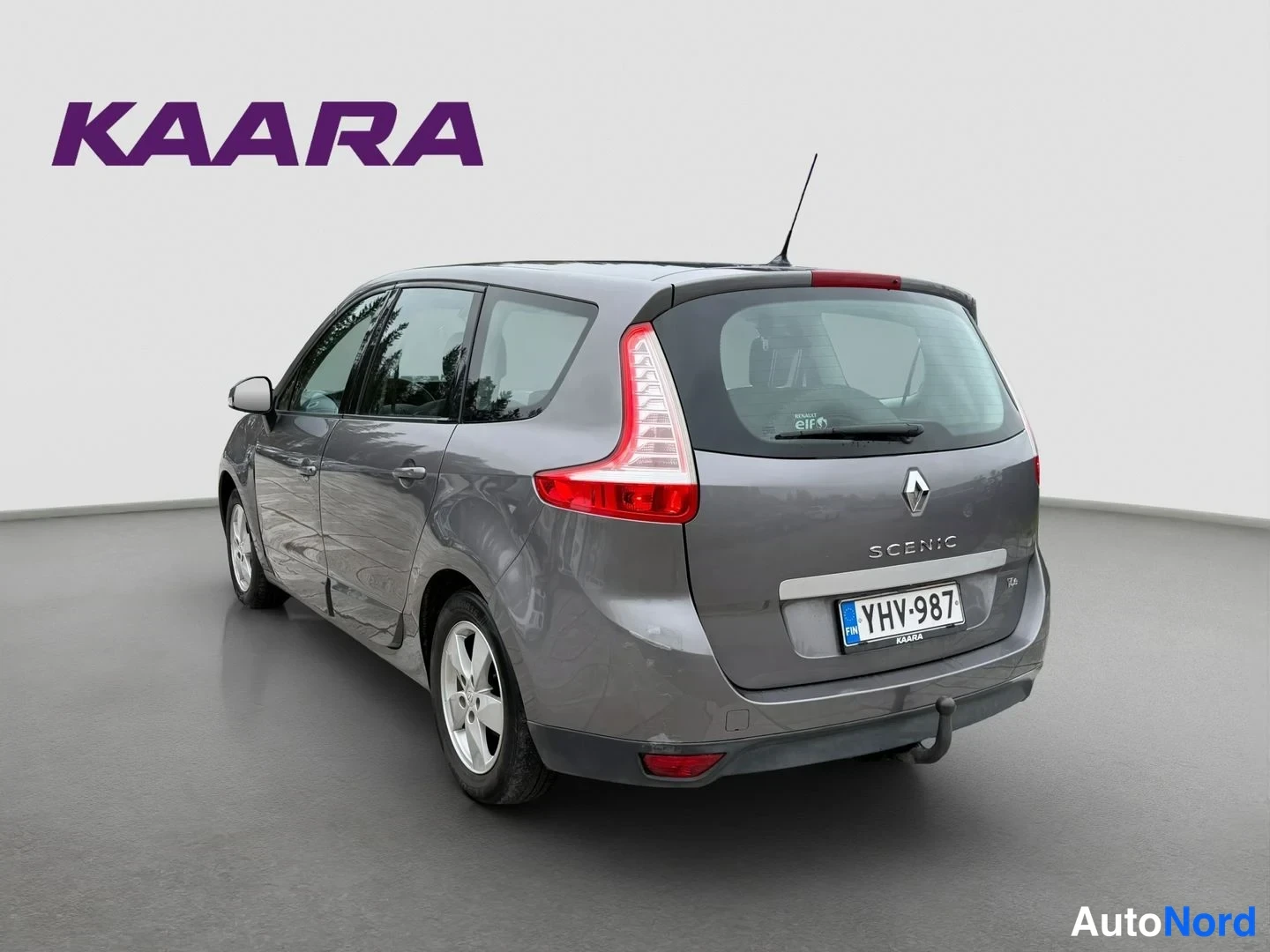 Takaviisto: Renault Grand Scenic - auton takakulma studiovalkoista taustaa vasten, rekisteritunnus näkyvissä.