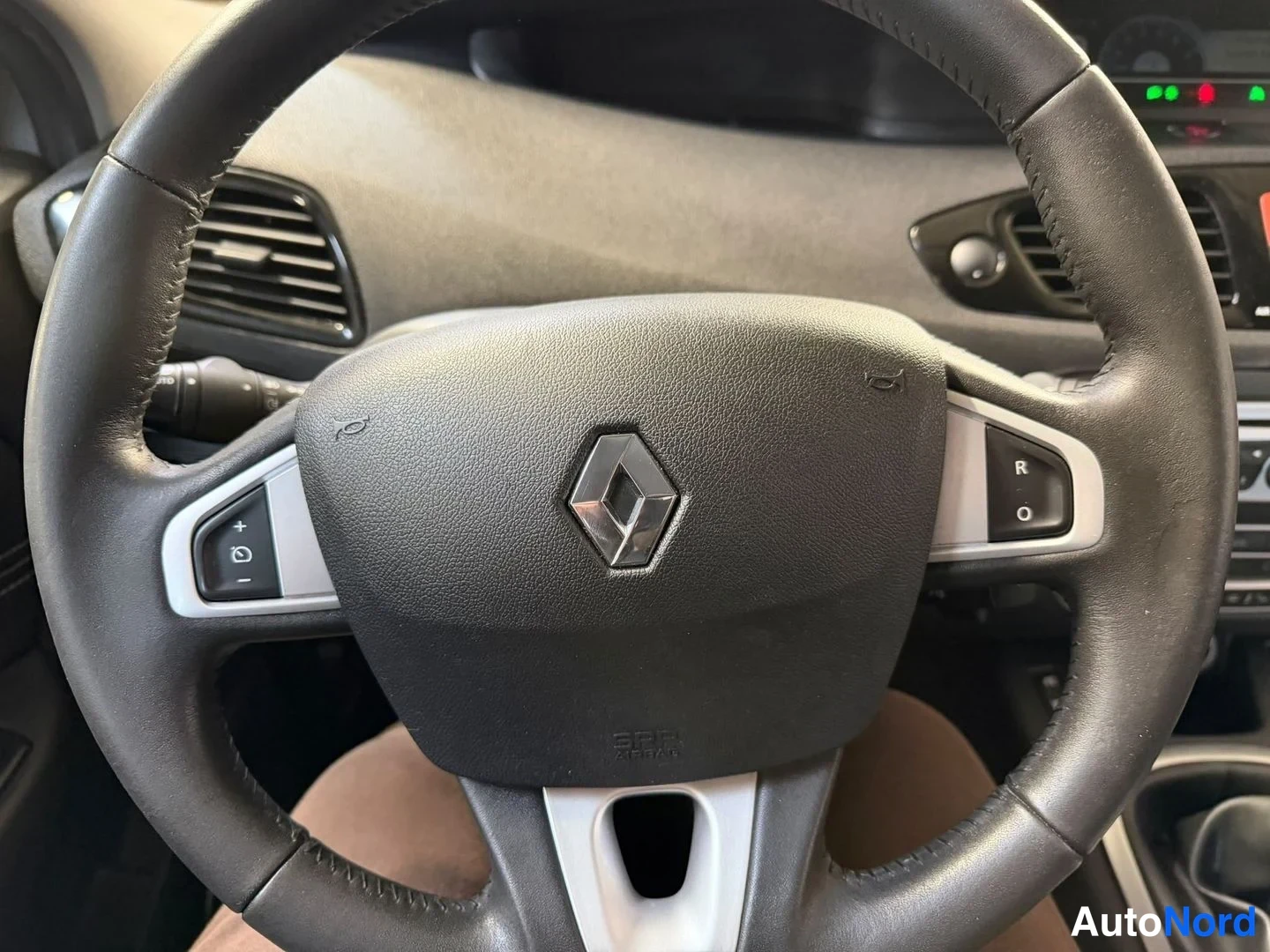 Muu: Ohjauspyörä lähikuvassa, Renault-tunnuksella ja äänensäätimillä pyörän puhalluksissa.