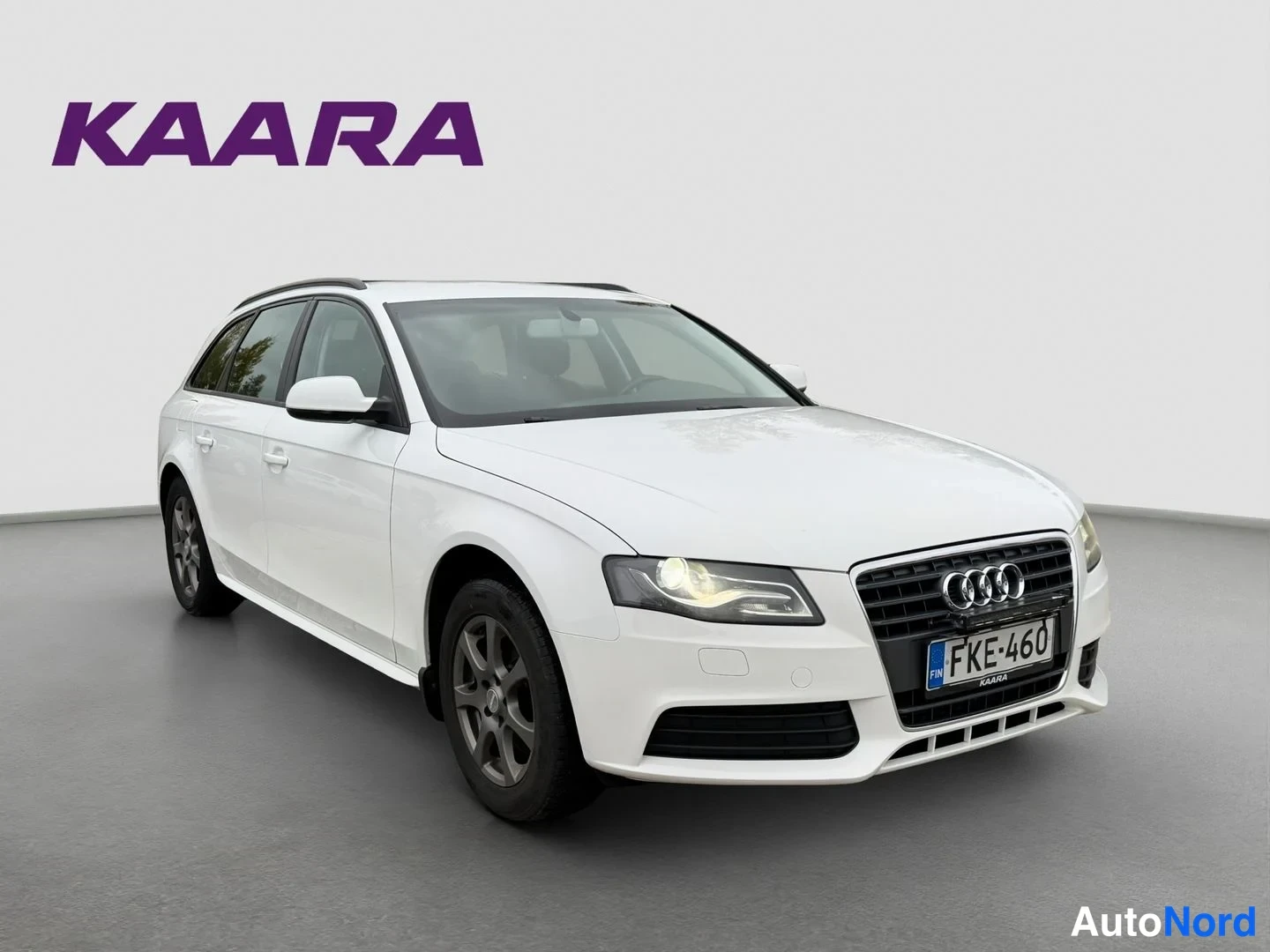 Etuviisto, nokka oikealle: Valkoinen Audi A4 Avant -farmari etukulmasta oikealle kuvattuna studiovalkoinen tausta, rekisteritunnus.