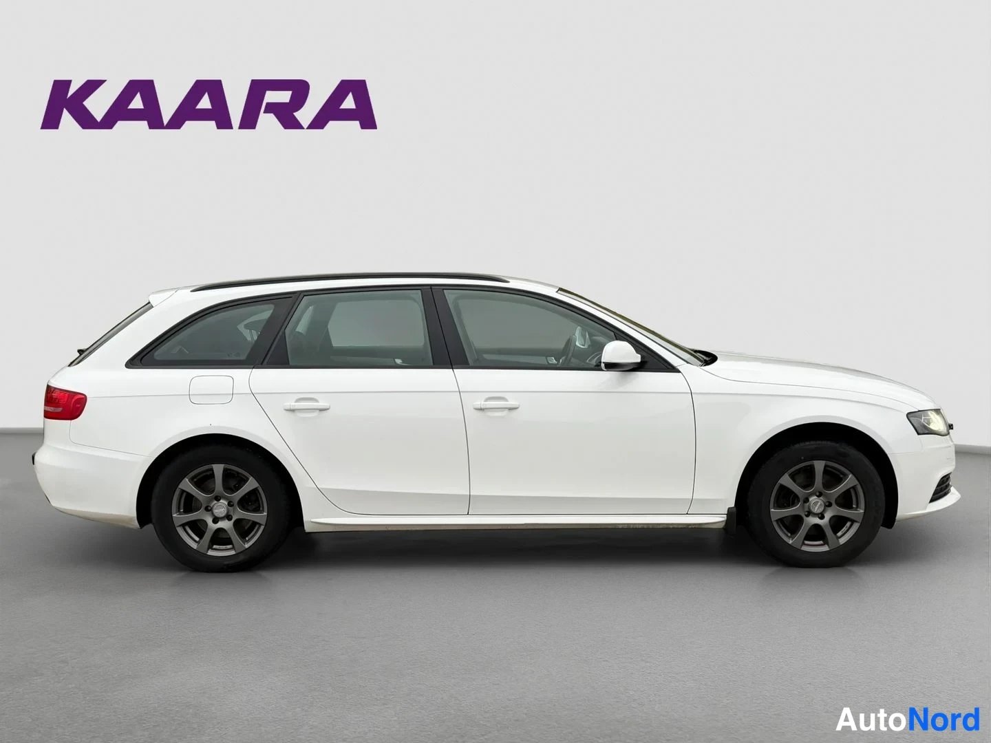 Sivulta: Valkoinen Audi A4 Avant -farmari sivukulmasta kuvattuna studiovalkoista taustaa vasten.