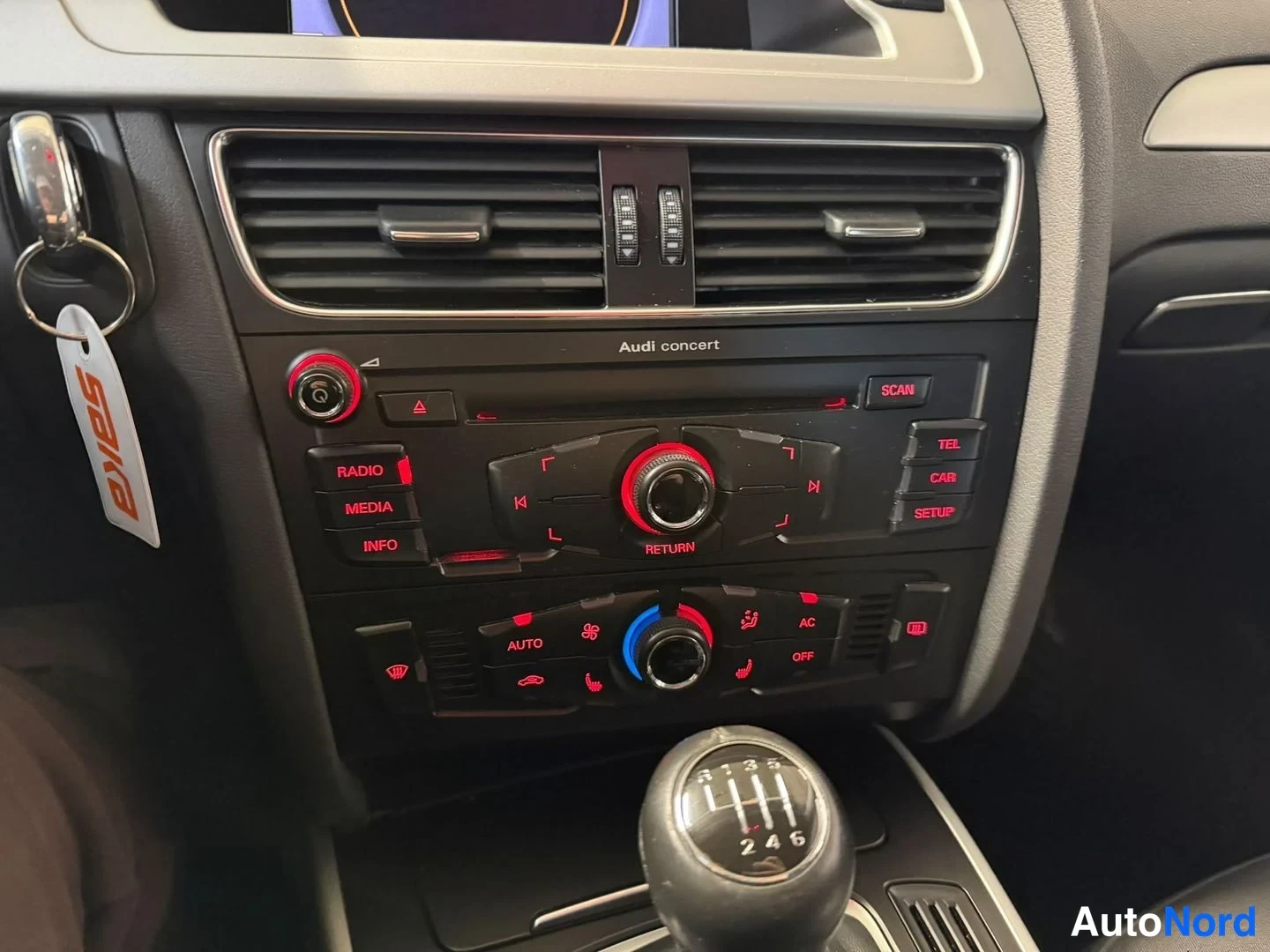 Yksityiskohta: Kojelaudan keskiosa: Audi concert -radio, automaattinen ilmastointi (AUTO, AC) ja 6-vaihteinen manuaalivaihde.