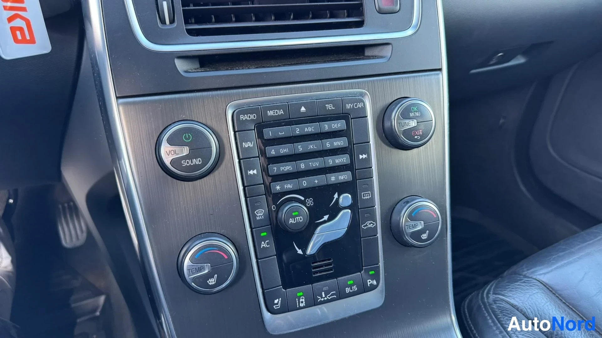 Muu: Keskiakseliston näppäimistö ja säätörit: RADIO, MEDIA, NAV, TEL, MY CAR, AC ja AUTO-napit; TEMP-säätörissä istutinlämmityskuvake.