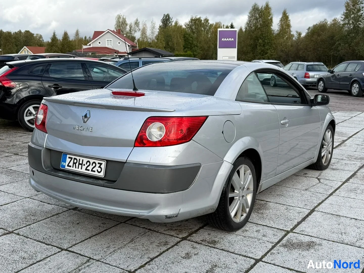 Takaviisto: Hopeanvärisen Renaultin takakulma vasemmalta, takakansi, taking koukku ja rekisteritunnus näkyvät.