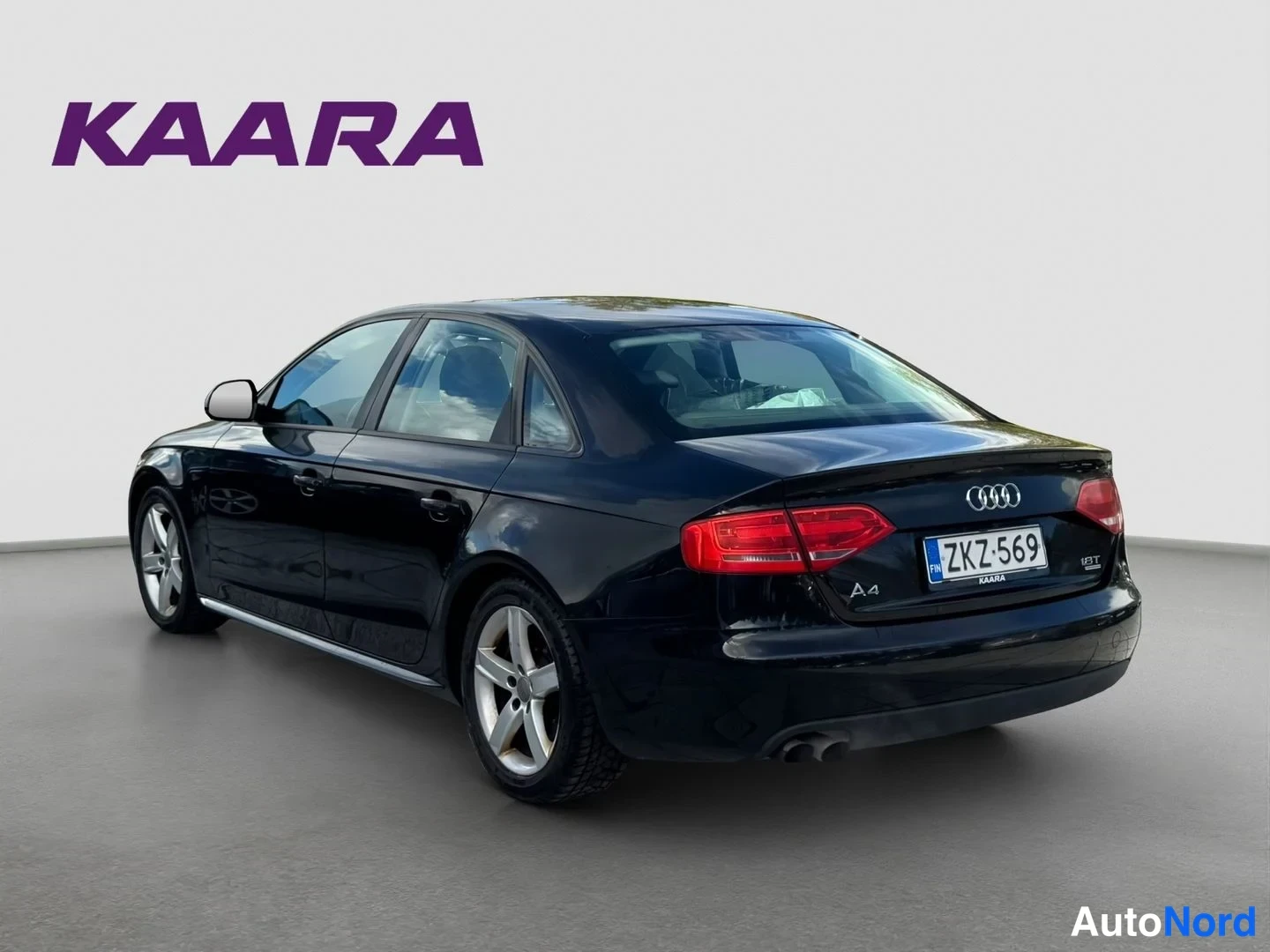 Takaviisto: Mustan Audi A4 -sedanin takakulma, rekisterikilpi, takana näkyy A4-merkintä ja Audi-Logo.