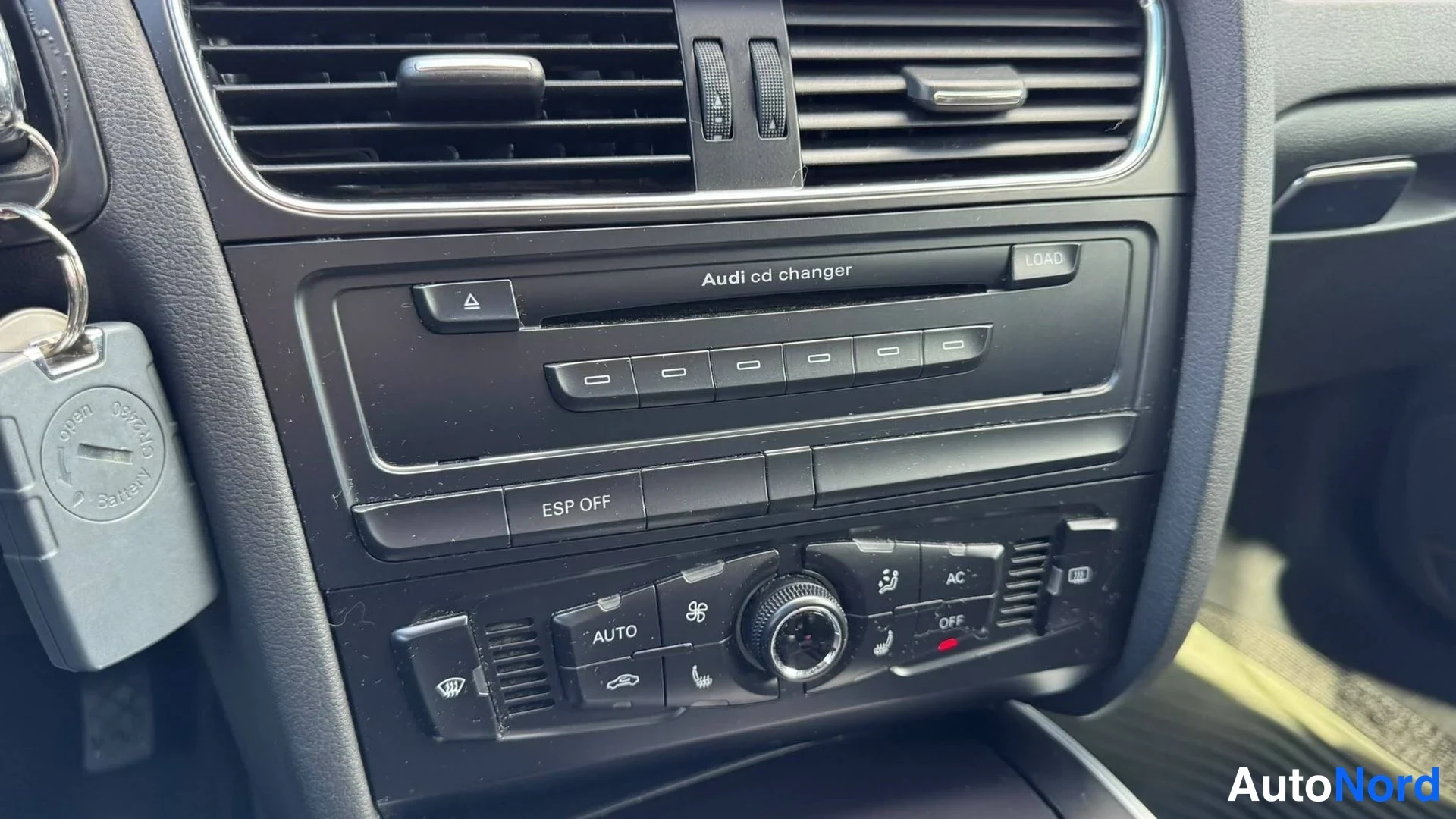 Yksityiskohta: Keskihaltion rivissä näkyy Audi cd changer -levyke sekä alla ESP OFF -kytkin ja automaattisen ilmastoinnin säätimet, mm. AUTO-, AC- ja OFF-napit; vasemmalla ava