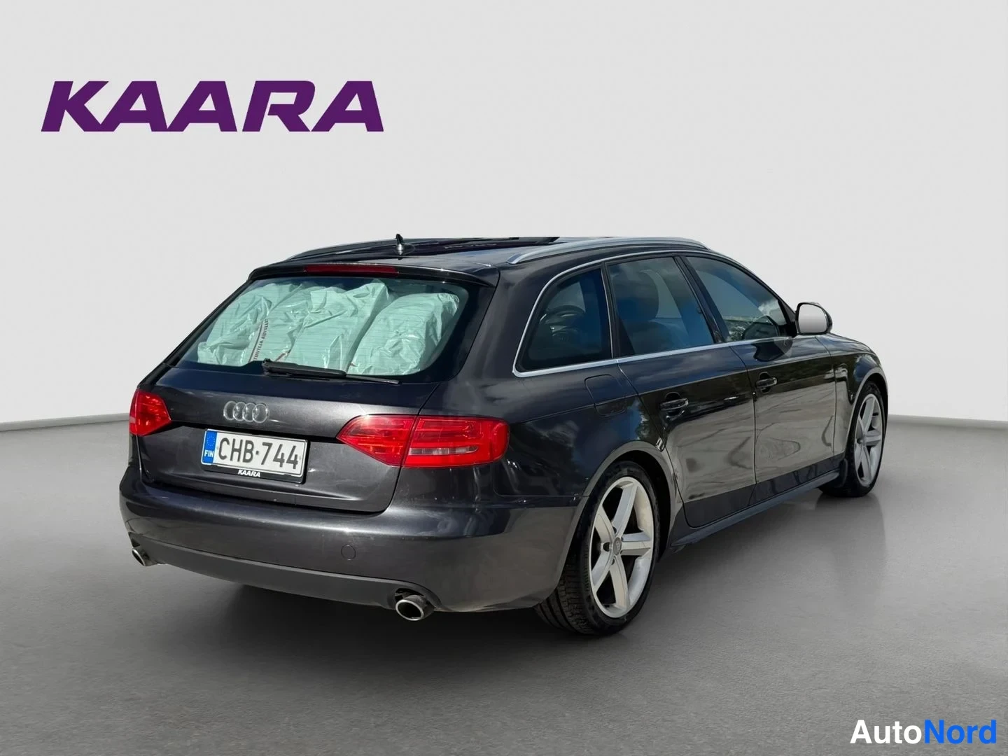Takaviisto: Tummanharmaa Audi A4 Avant taka­viistosta, rekisteritunnus näkyy taka­ovessa.