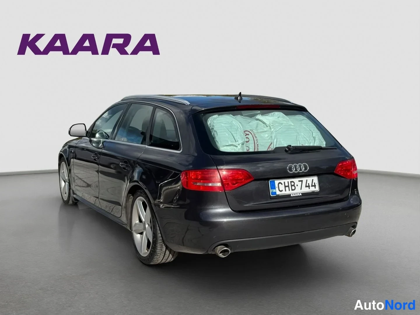 Takaviisto: Audi A4 Avantin takaosa vinosti takaa: tumma korivalaisu, punaiset takavalot, rekisterikilpi ja pakoputki näkyvät.