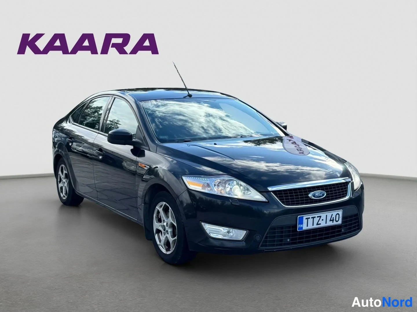 Etuviisto, nokka oikealle: Mustan Ford Mondeo -sedanin etukulma toiselta suunnalta, rekisteritunnus.