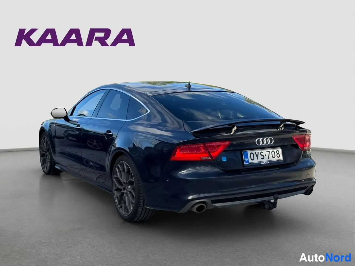 Takaviisto: Audi A7:n takaosa kolmannelta neljännekseltä, tummansininen koripeltu, rekisterikilpi, takaoppaat ja loivaSpoiler näkyvät.