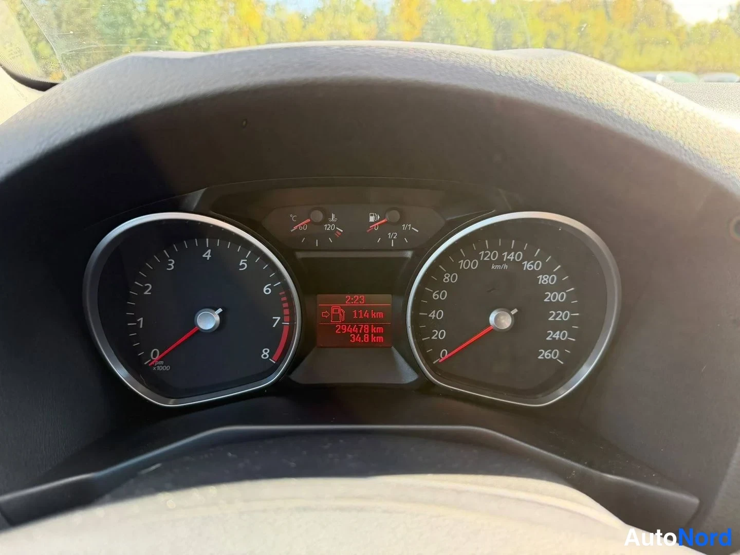 Edestä: Mittaristona kierrosmittari ja nopeusmittari; näytössä lukee 2:23, 114 km, 294478 km ja 34,8 km.