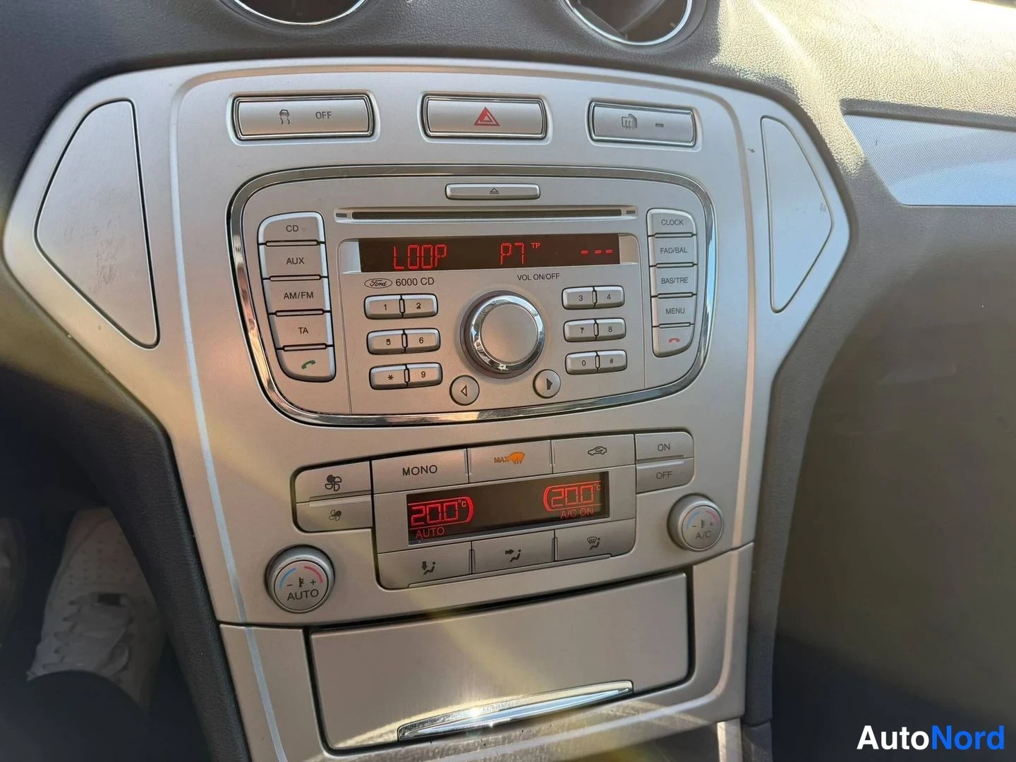 Yksityiskohta: Kojelautakeskus, jossa Ford 6000 CD -radio (CD, AUX, AM/FM, TA) ja kaksivyöhyke-automaattilmastointi, näytöt 200° ja AIC ON.