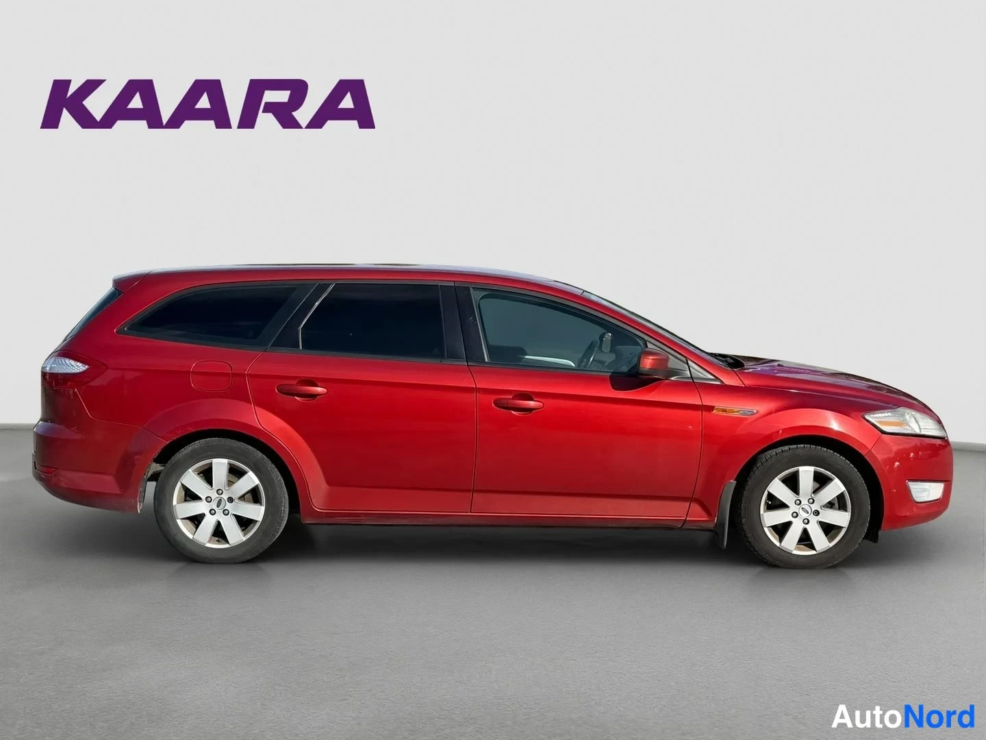 Etuviisto, nokka oikealle: Punainen Ford Mondeo -farmari sivulta etukulmasta, valkoinen studiovaaka tausta.