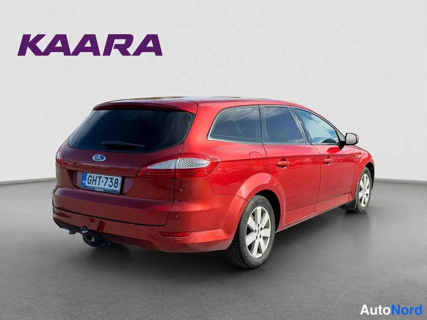 Takaviisto: Ford Mondeo Wagon -asema-auton takaosan kolmasosakulmakuva, punainen koristus rekisteritunnus, asennettu vetokoukku näkyvissä.