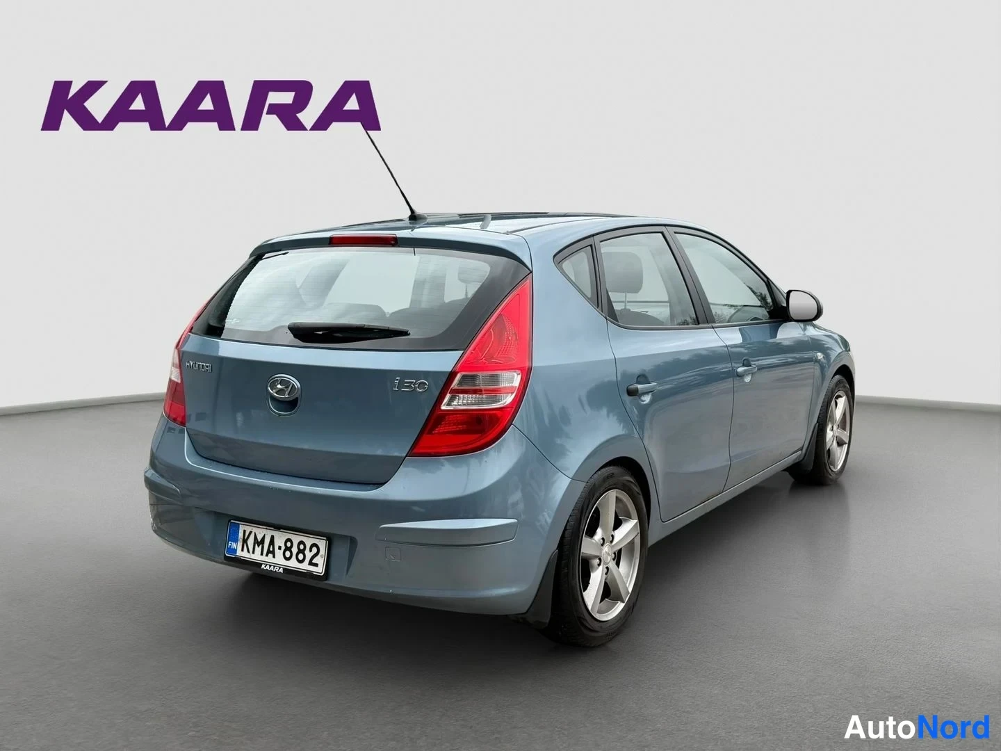 Takaviisto: Sininen Hyundai i30 -henkilöauto taka- ja sivukulmasta kuvattuna, perä vasemmalla, studioympäristössä.