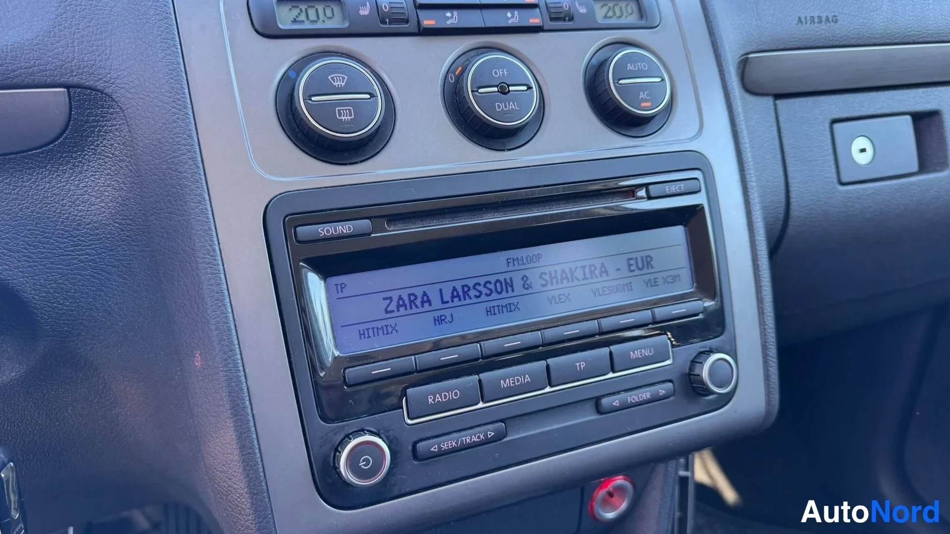 Sivulta: Kojelaudan radio: RCD-tyyppinen radio-CD-soitin, näytöllä 'ZARA LARSSON & SHAKIRA - EUR' (FM100P), painikkeet RADIO, MEDIA, TP, MENU, SOUND ja EJECT.