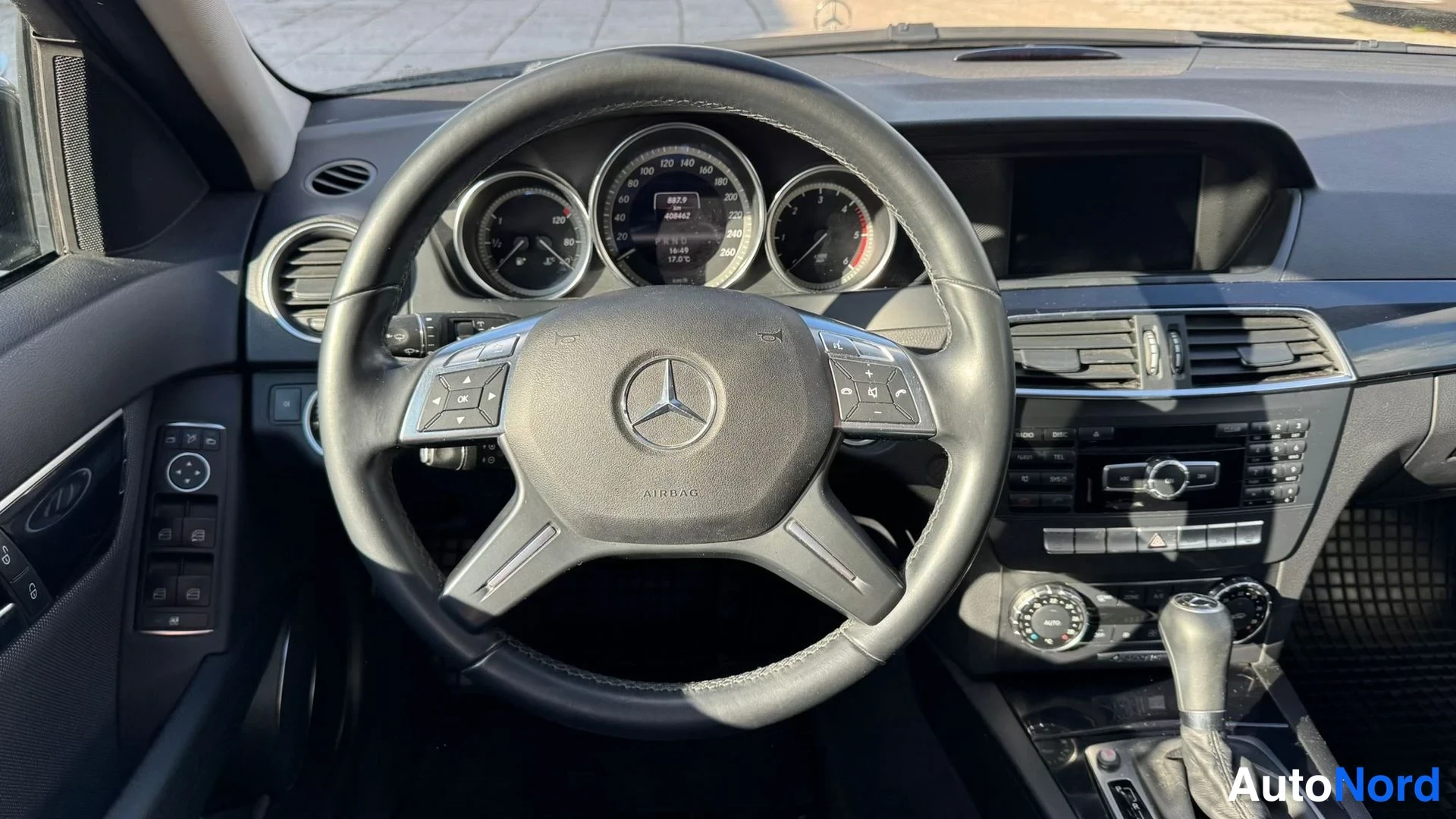 Muu: Ohjauspyörän lähikuva: Mercedes-tähtimerkki ja AIRBAG-teksti, mittaristo ja osa kojetaulusta taustalla.