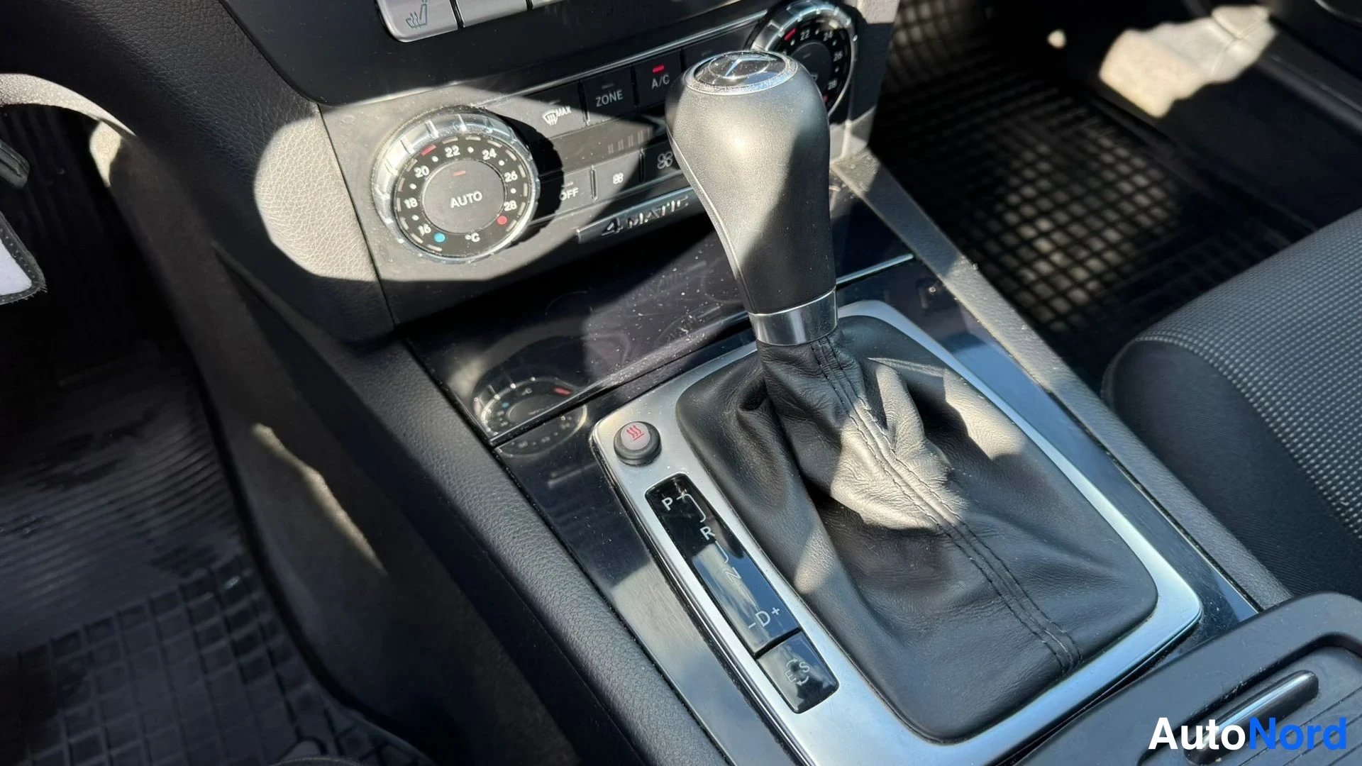 Muu: Automaattivaihteen vaihdekeila istuimen välissä, P R D-nappirivillä ja 4MATIC-merkinnällä kojelaudan alla.