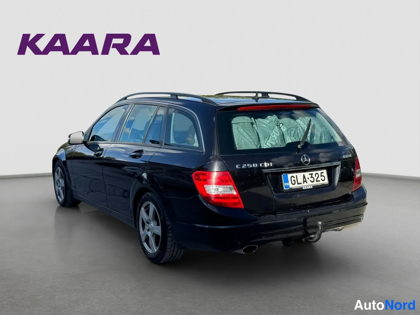 Takaviisto: Mustan farmariauto takaa kolmesta neljäsosaan kuvattuna, takapuskuri ja perävaunu