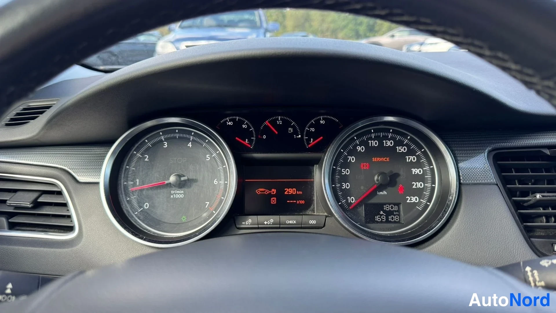 Edestä: Mittaristo lähikuvassa: vasemmalla kierroslukumittari (x1000), oikealla nopeusmittari asteikolla 10–230 km/h, keskellä pienet tarkemmat mittarit ja näyttö, joss
