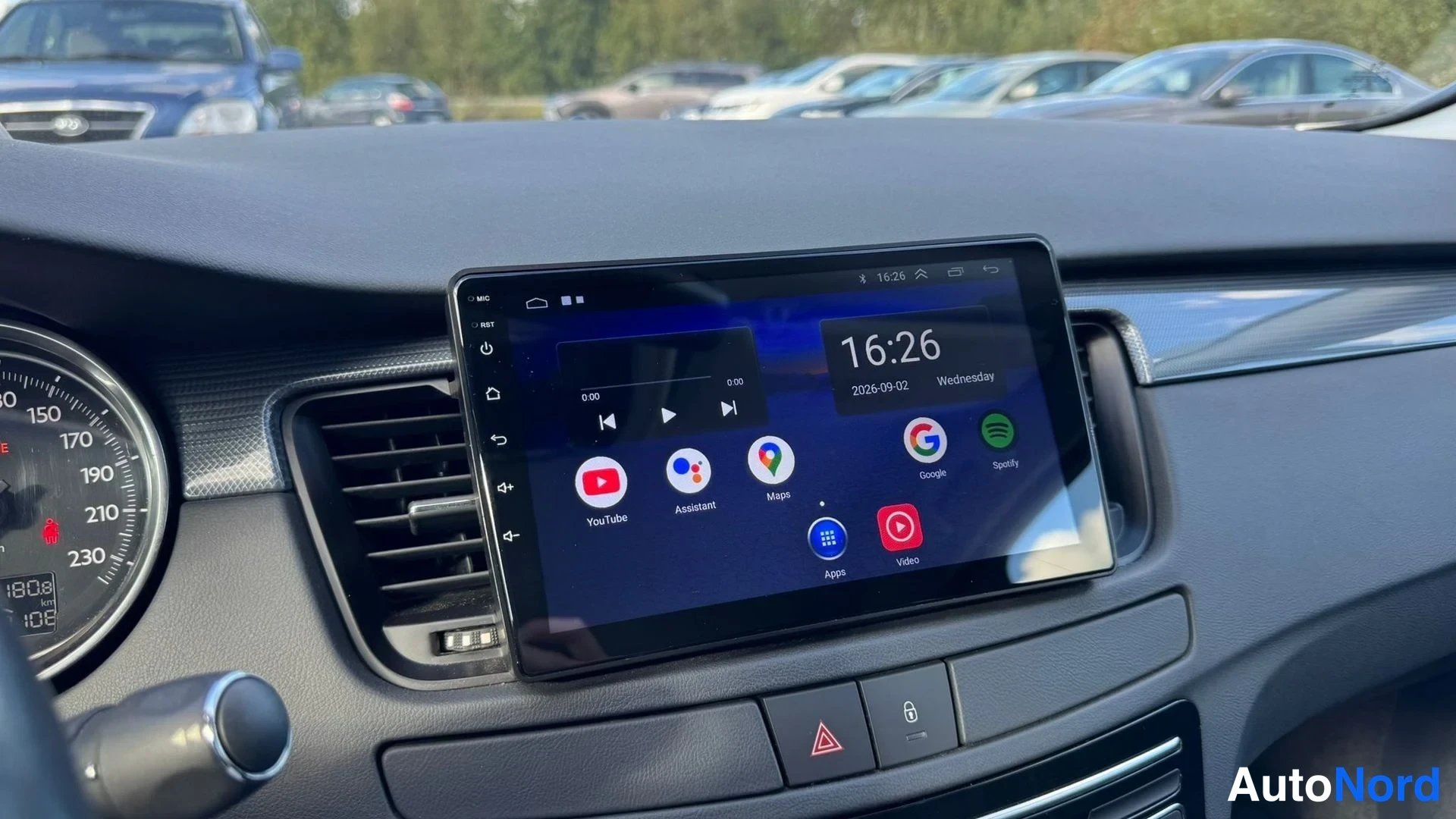 Yksityiskohta: Kojetilassa suuri kosketusnäyttö, jolla näkyy Android-käyttöliittymä sovelluksilla kuten YouTube, Google Maps ja Spotify; kello näyttää 16:26 2.9.2026. Vasemmal
