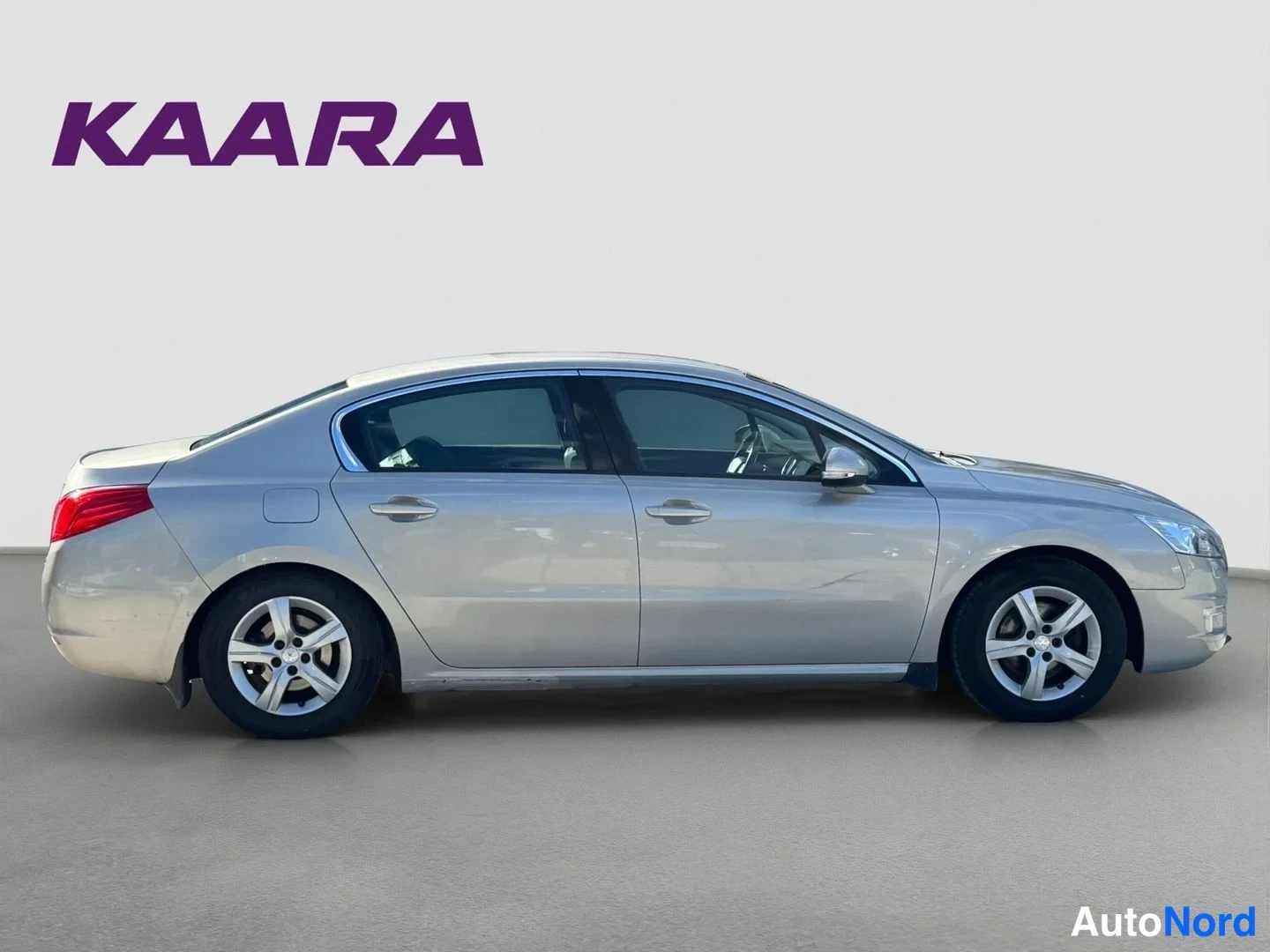 Takaviisto: Auton sivuprofiili oikealta, hopeanbeige sedan.