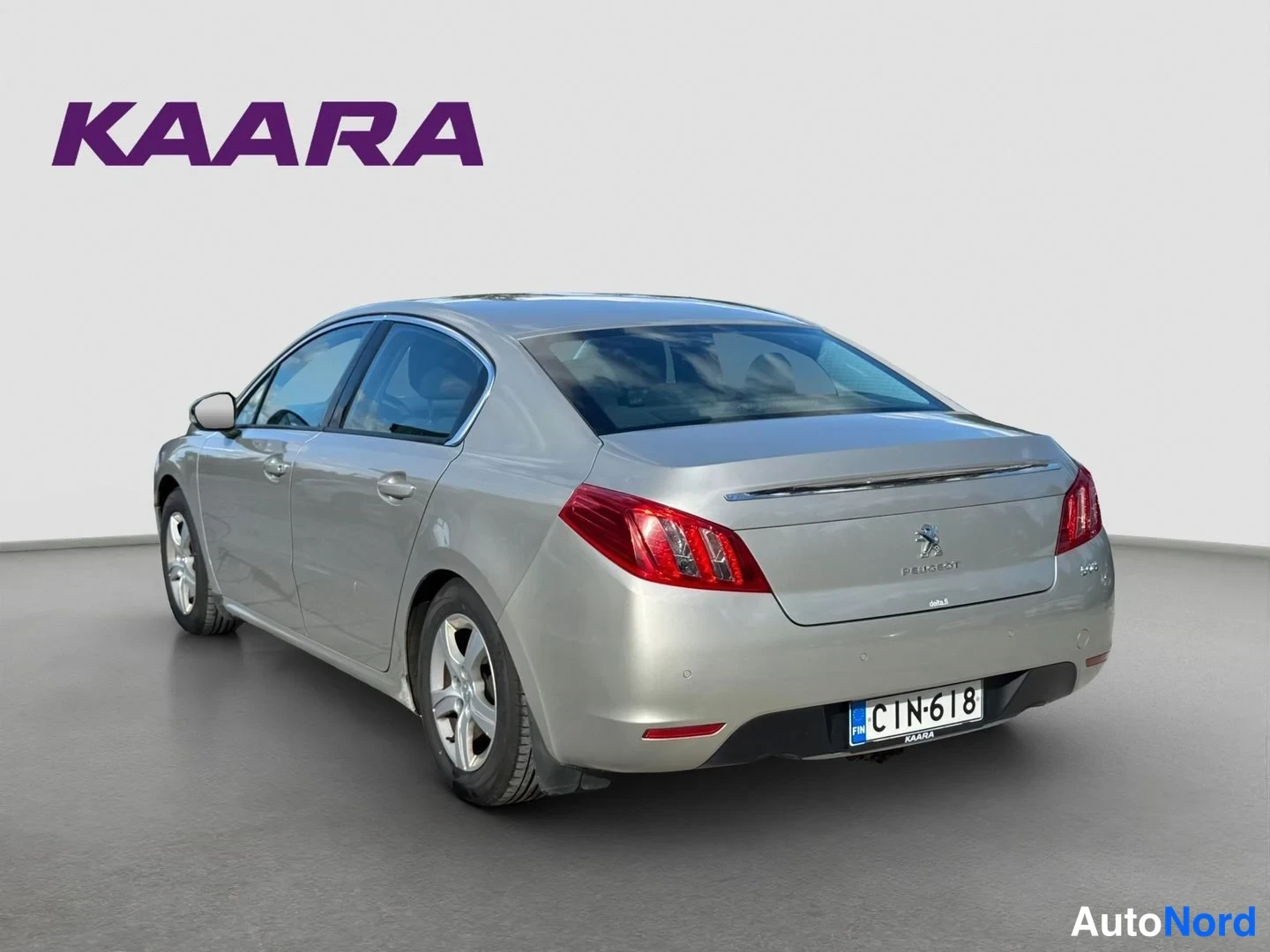 Takaviisto: Peugeot 508 -sedanin takaosa ja vasen kylki kolmesta neljäsosaan -kulmasta; hopeanhohtoinen koripaneeli, punaiset takavalot ja rekisteritunnus.