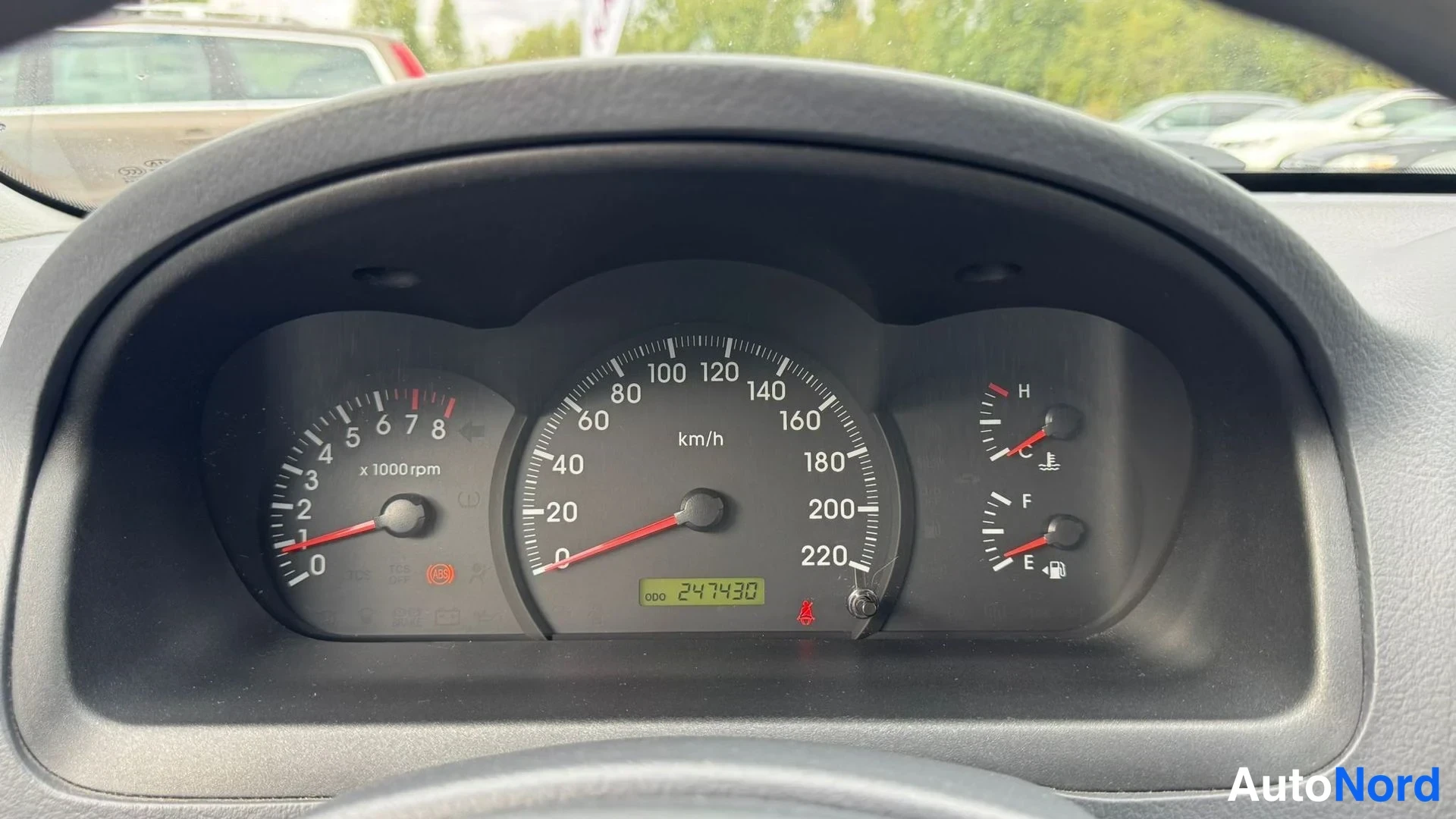 Muu: Mittariston lahiphotokuva: nopeusmittari asteikkoon 220 km/h, kierrosmittari ja polttoaine- samt lampomittarit, matkamittari lukee 247430 km.