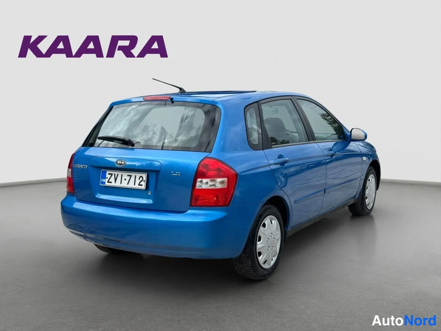 Takaviisto: Sininen Kia Cerato -viistoperä takaokoliskulmasta, rekisteritunnus ja takalasi-antenni näkyvissä.