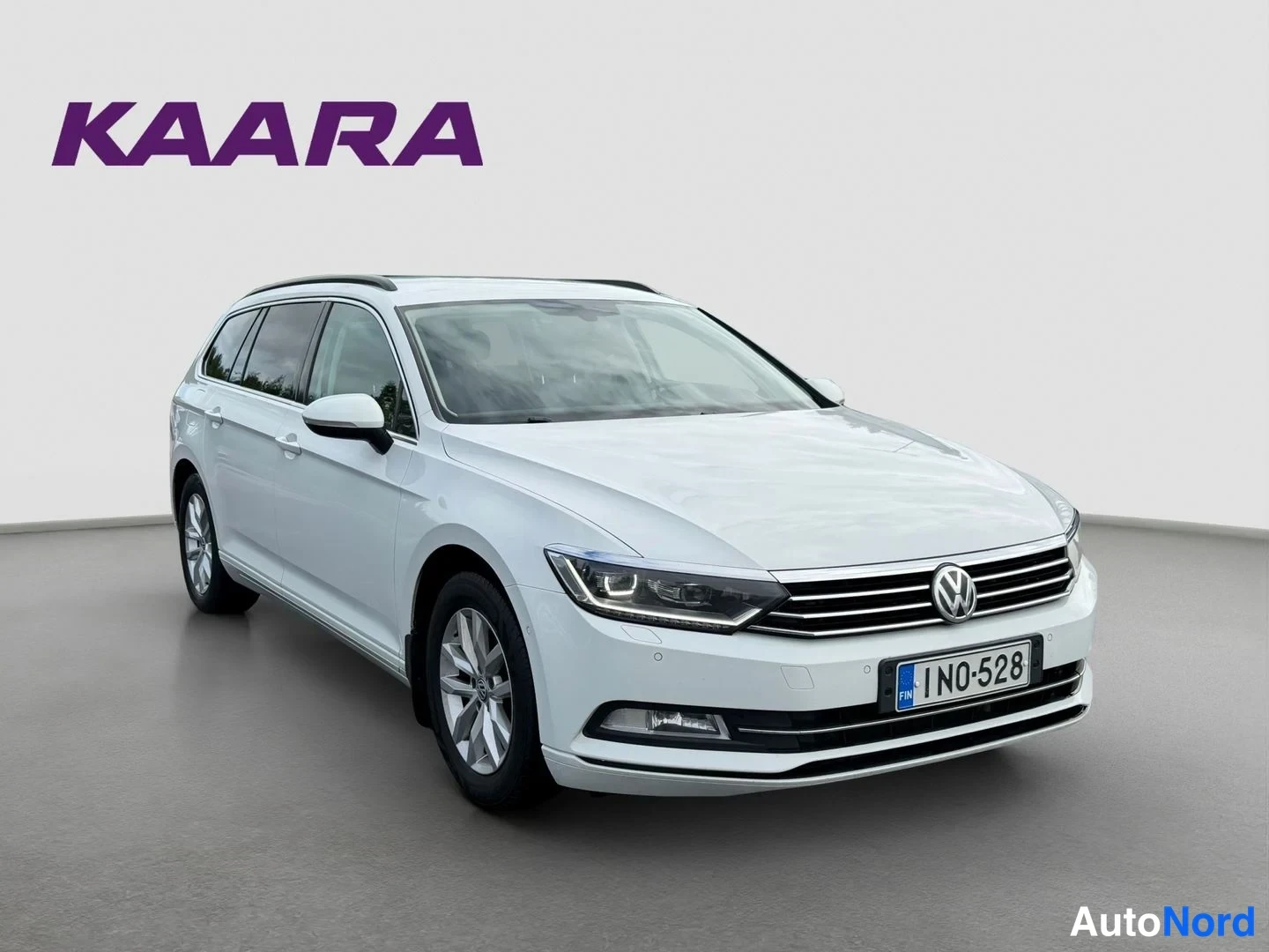 Etuviisto, nokka oikealle: Valkoinen Volkswagen Passat Variant farmari etuviistosta oikealta, rekisterikilpi IN0-528, harmaassa studiossa