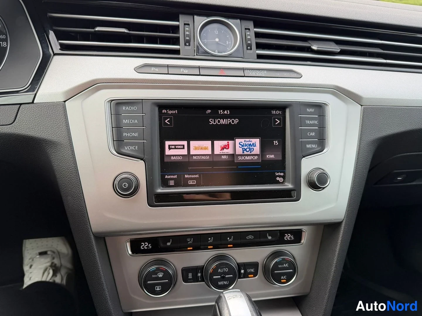 Yksityiskohta: Kojelaudan keskikäytävä: radio-näyttö soittamassa kanavaa Radio SuomiPop, ympärillä RADIO-, MEDIA-, PHONE-, VOICE-, NAV-, TRAFFIC- ja CAR-painikkeet, alla kaksi