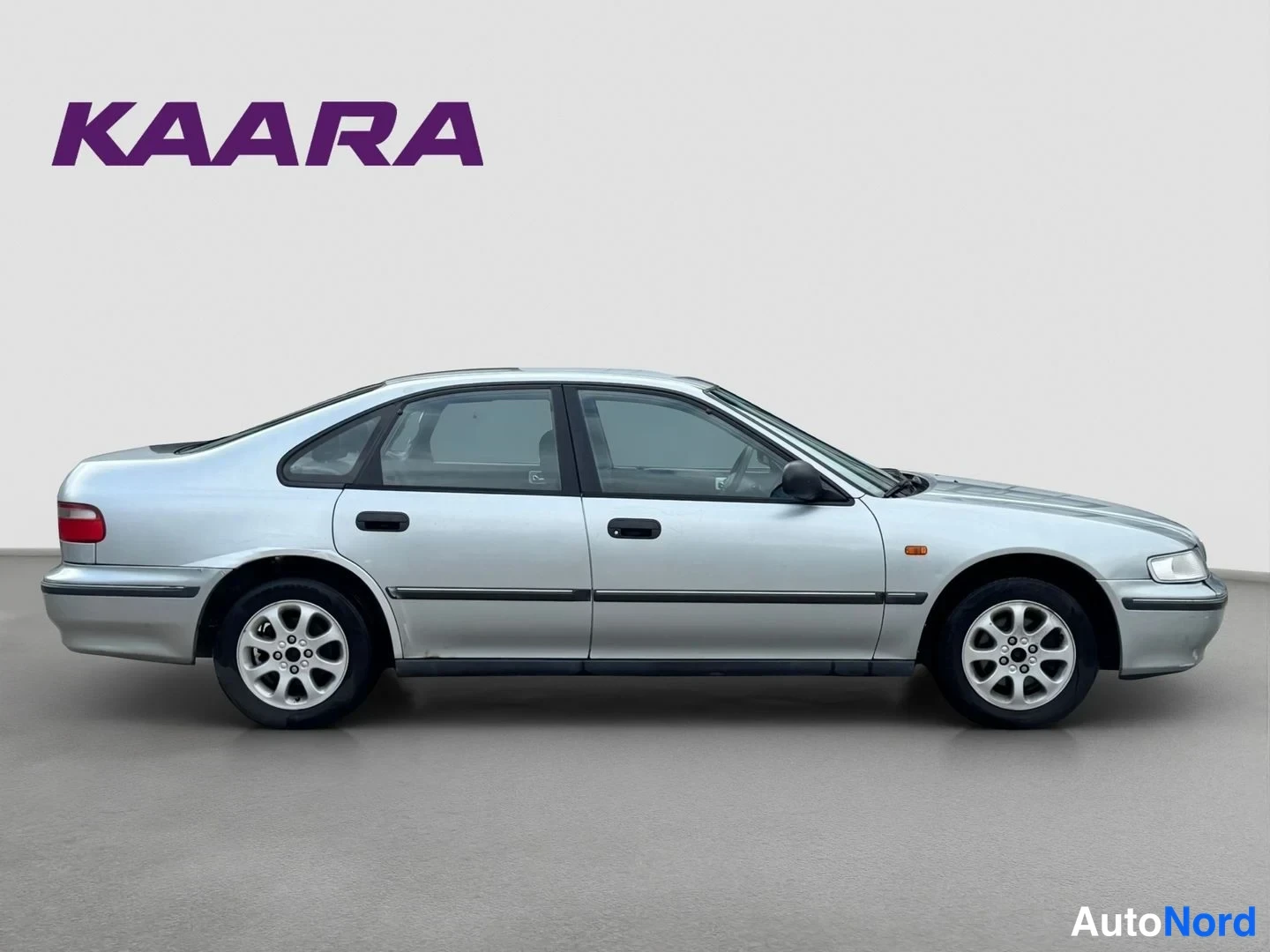 Sivulta: Hopeisen Honda Accord -sedanin sivuprofiili, neliovinen sedan, studyotä valkoista taustaa vasten.