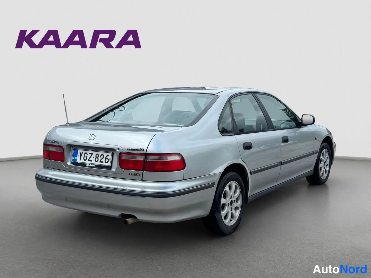 Takaviisto: Hopeinen Honda Accord -sedan takakulmasivulta, rekisteritunnus, takavalojen ja peräluukun näkyessä.