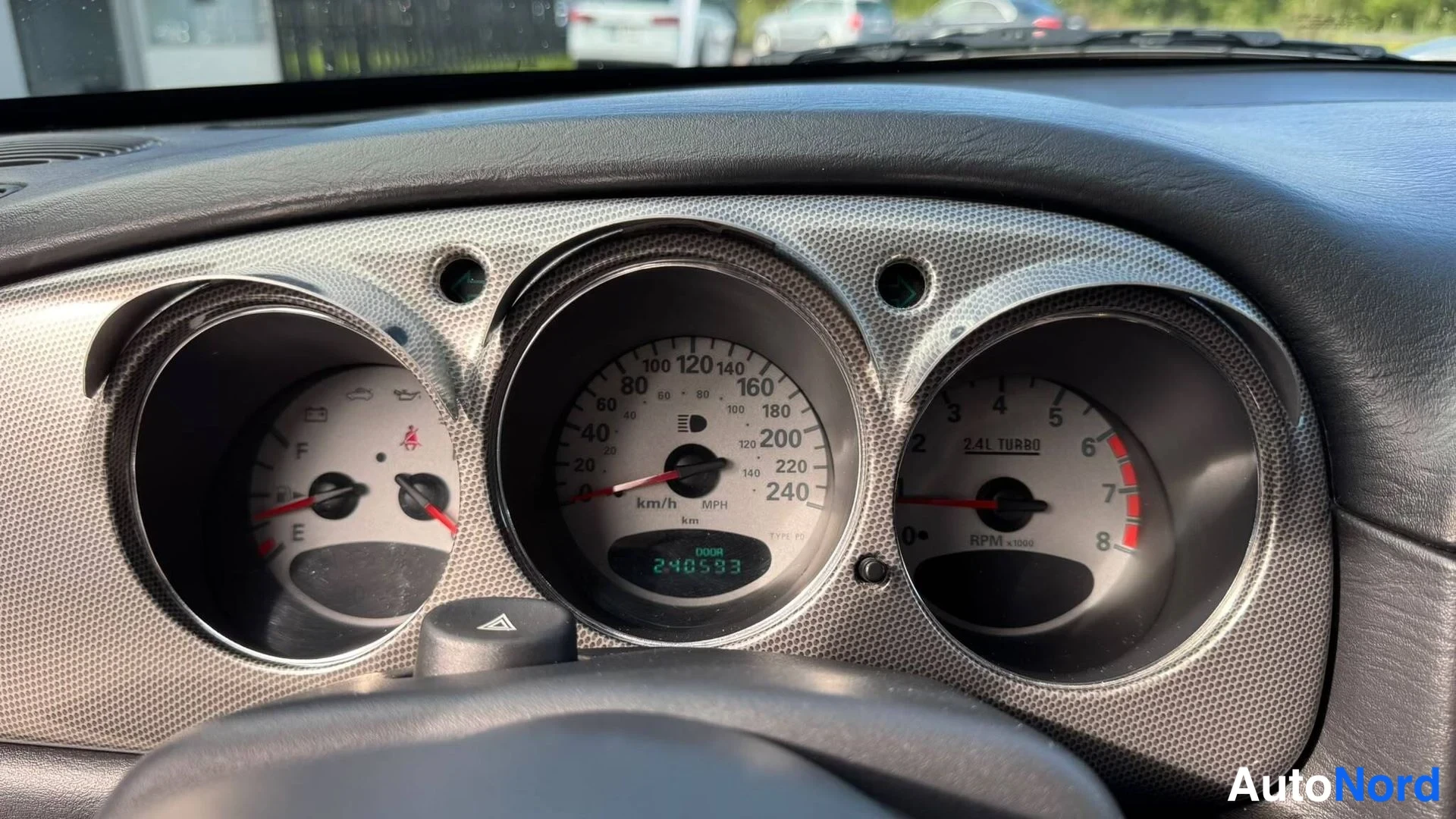 Etuviisto, nokka vasemmalle: Mittaristo lähikuvassa: nopeusmittari asteikko 240 km/h, kierrosmittari merkinnällä 2.4L TURBO, matkamittari 240583 km.