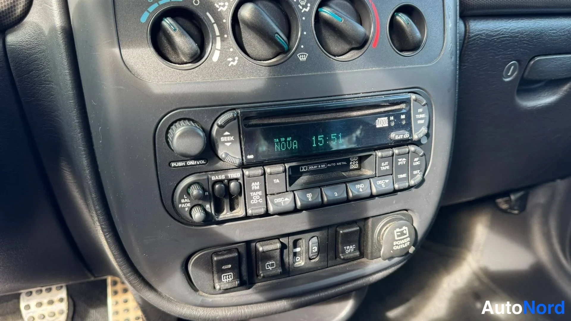 Muu: Kojelaudan keskusta: radio- ja kasettimedianäyttö 'NOVA 15:51', CD-luukku, ilmastointisäätimet ja nappeja.