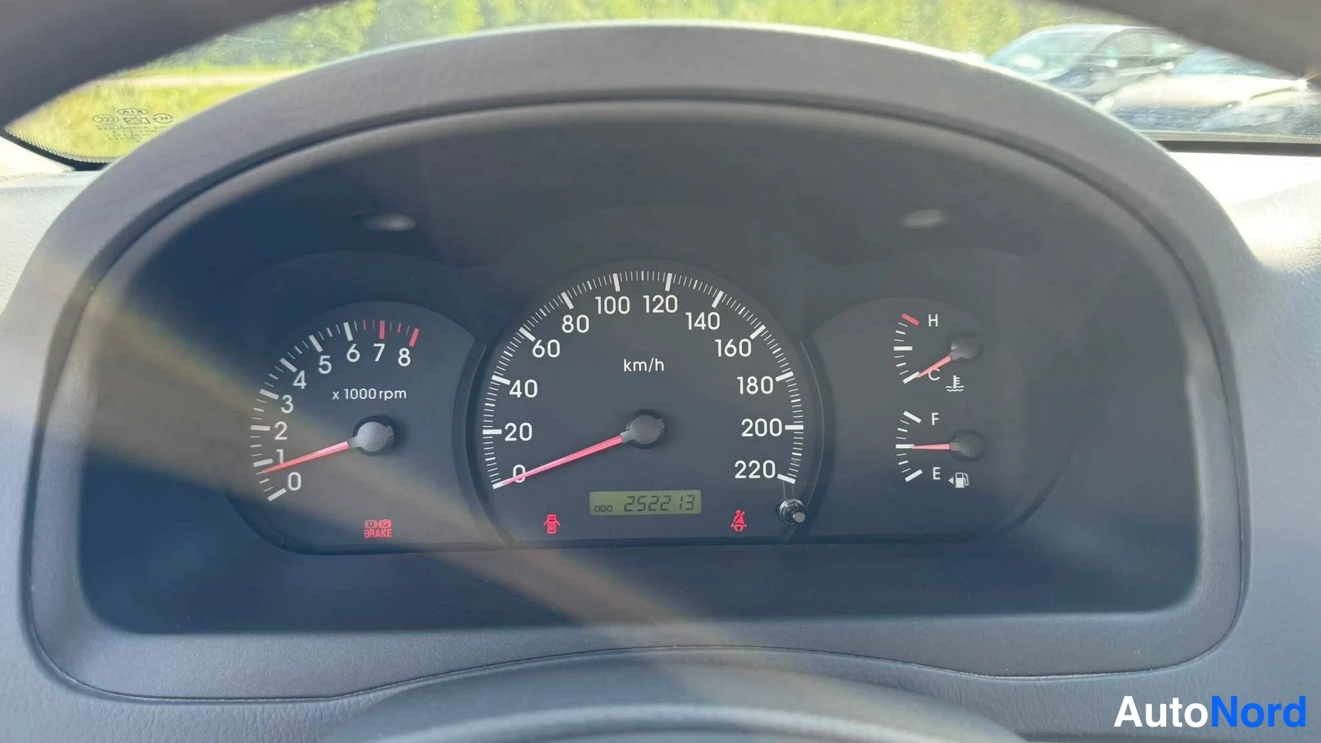 Muu: Kojelaudan mittaristo lähikuvassa: nopeusmittari 220 km/h, kierrosmittari ja näyttö 252213 km.