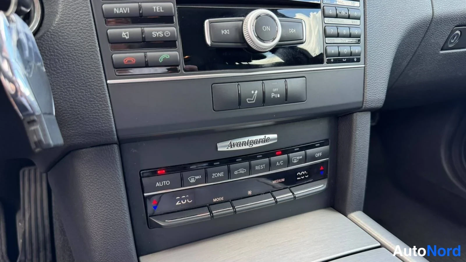 Muu: Kaksivyöhykkeen automaattinen ilmastointipaneeli (AUTO, ZONE, REST, A/C) ja sen yläpuolella Avantgarde-teksti.