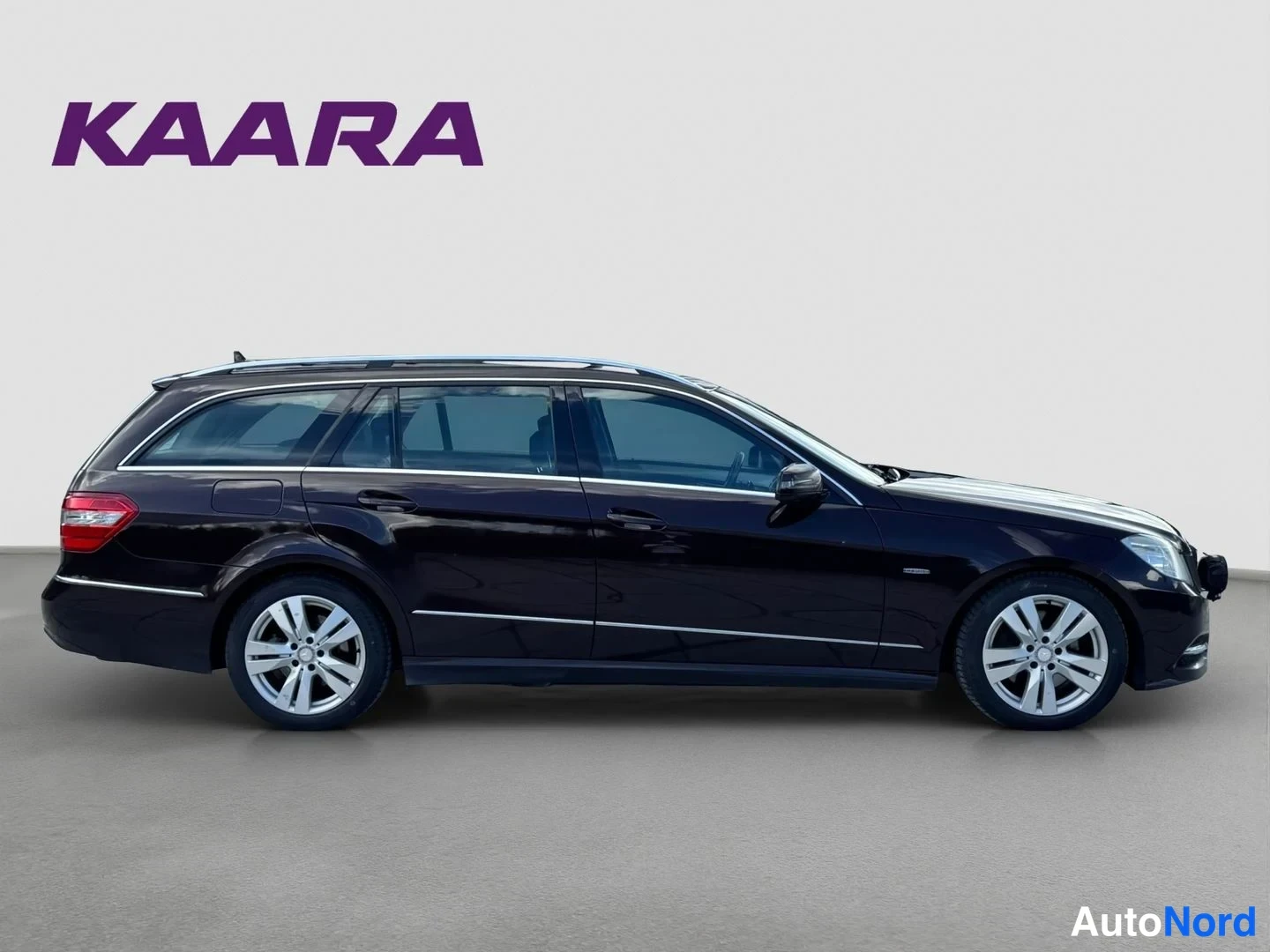 Etuviisto, nokka oikealle: Mercedes-Benz E-sarjan farmari sivulta oikealta, tummanruskea koriväri, oikea kylki ja etuosa näkyvissä.