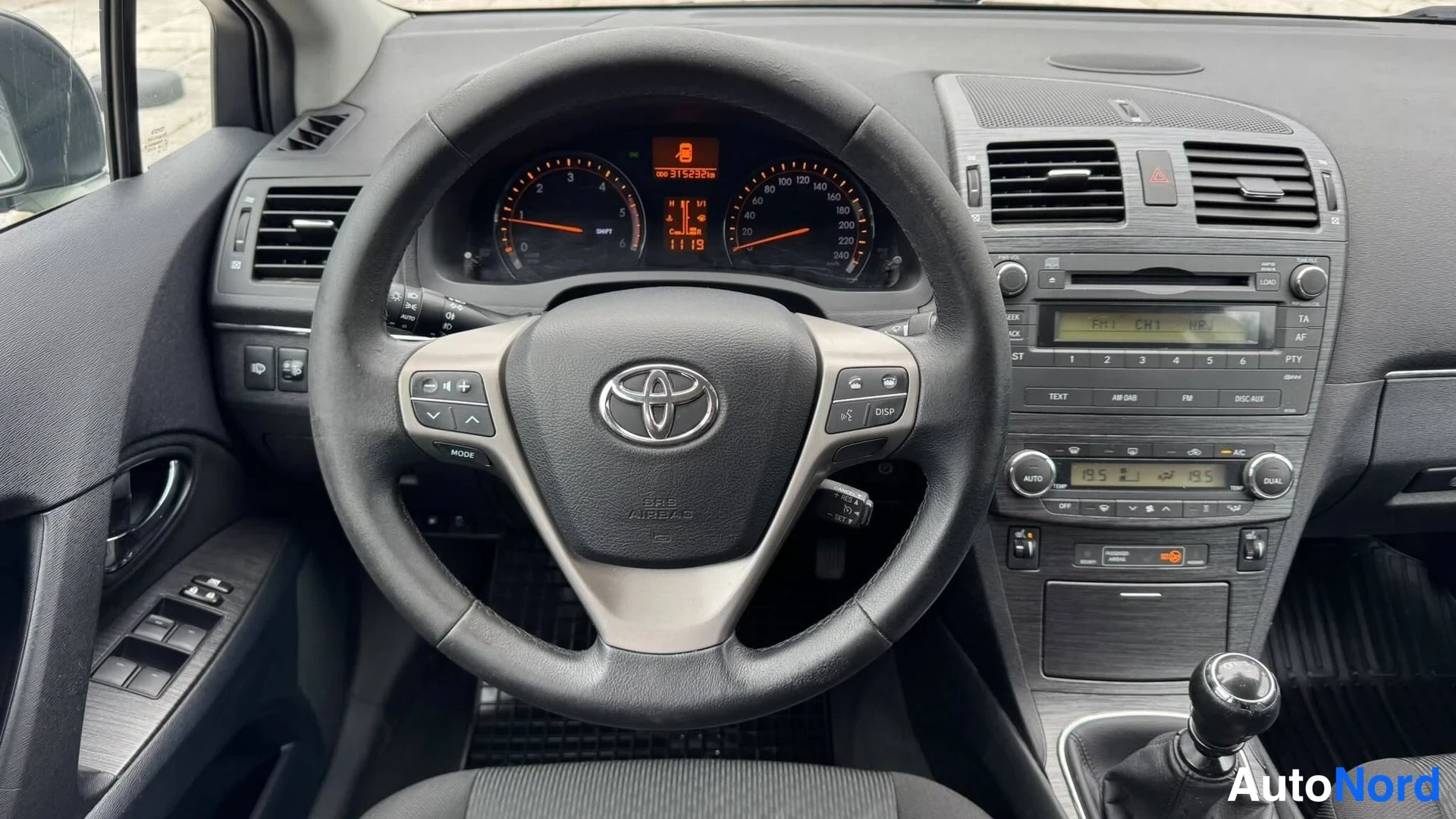 Muu: Kuljettajan paikalta kuvattu ohjaamo: Toyota-ohjauspyörä ja kojetaulon mittarit, joissa lukema 315292 km, sekä näppäimistö ja ääniohjaus isäntäpaneelissa.