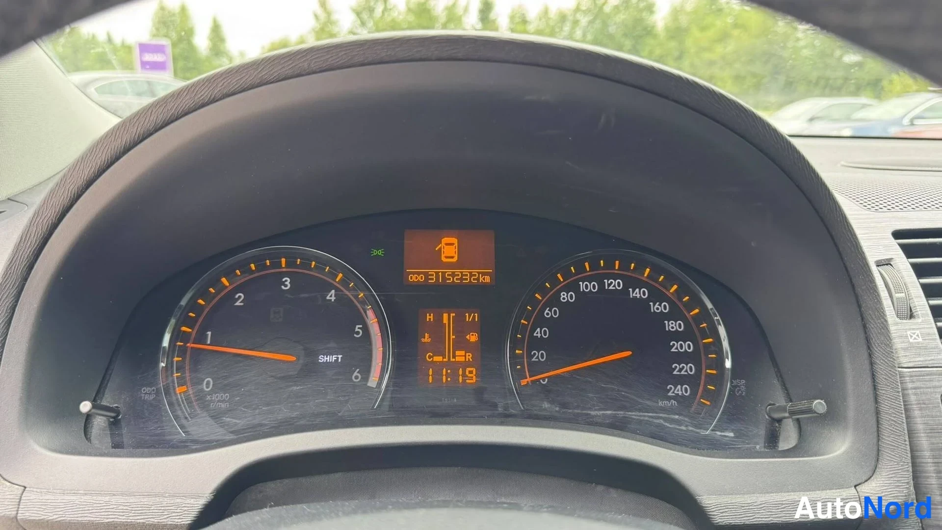 Muu: Lähikuva analogisista kojetaulin mittareista: nopeusmittari 240 km/h asti, kierroslukumittari ja oranssi näyttö lukemalla 315292 km.