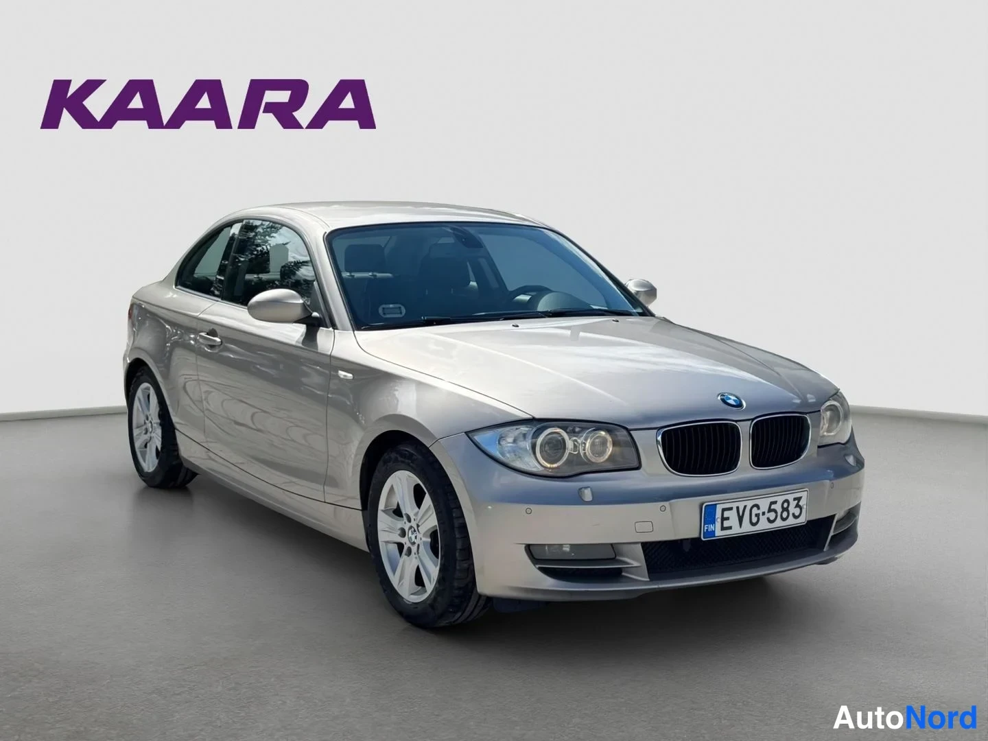 Etuviisto, nokka oikealle: Kultava BMW Coupé edestä oikealta kolmeneljänneksen kulmasta, rekisteritunnus.