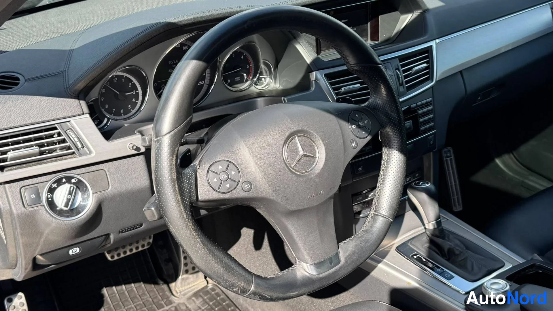 Muu: Ohjaamon kojelauta ja Mercedes-tunnuksellinen ohjauspyörä lähikuvassa.