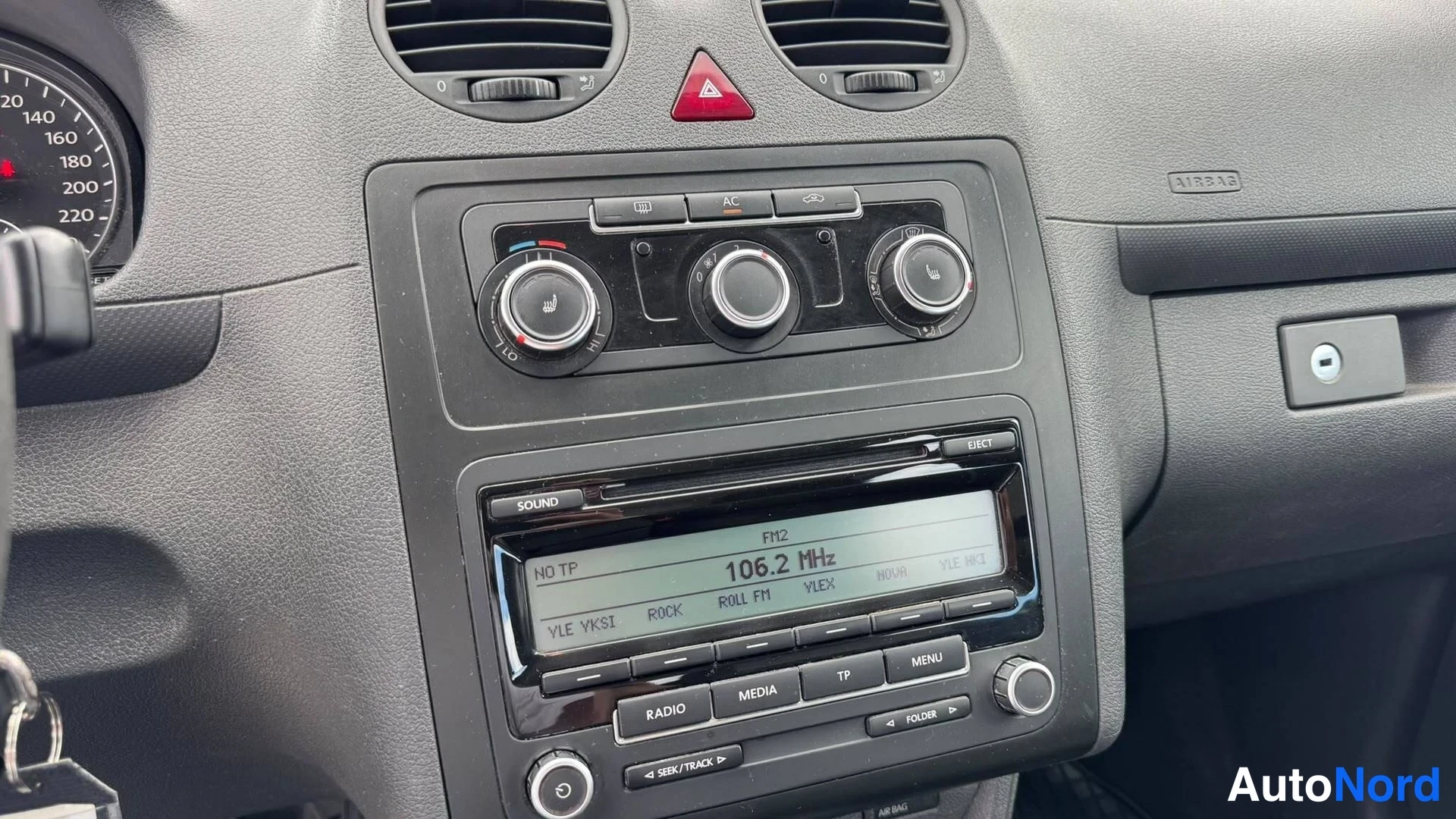 Yksityiskohta: Kojelaudan keskusta: manuaali-ilmastointi, radio ja varoitusvalot Volkswagen Caddyn sisustassa.