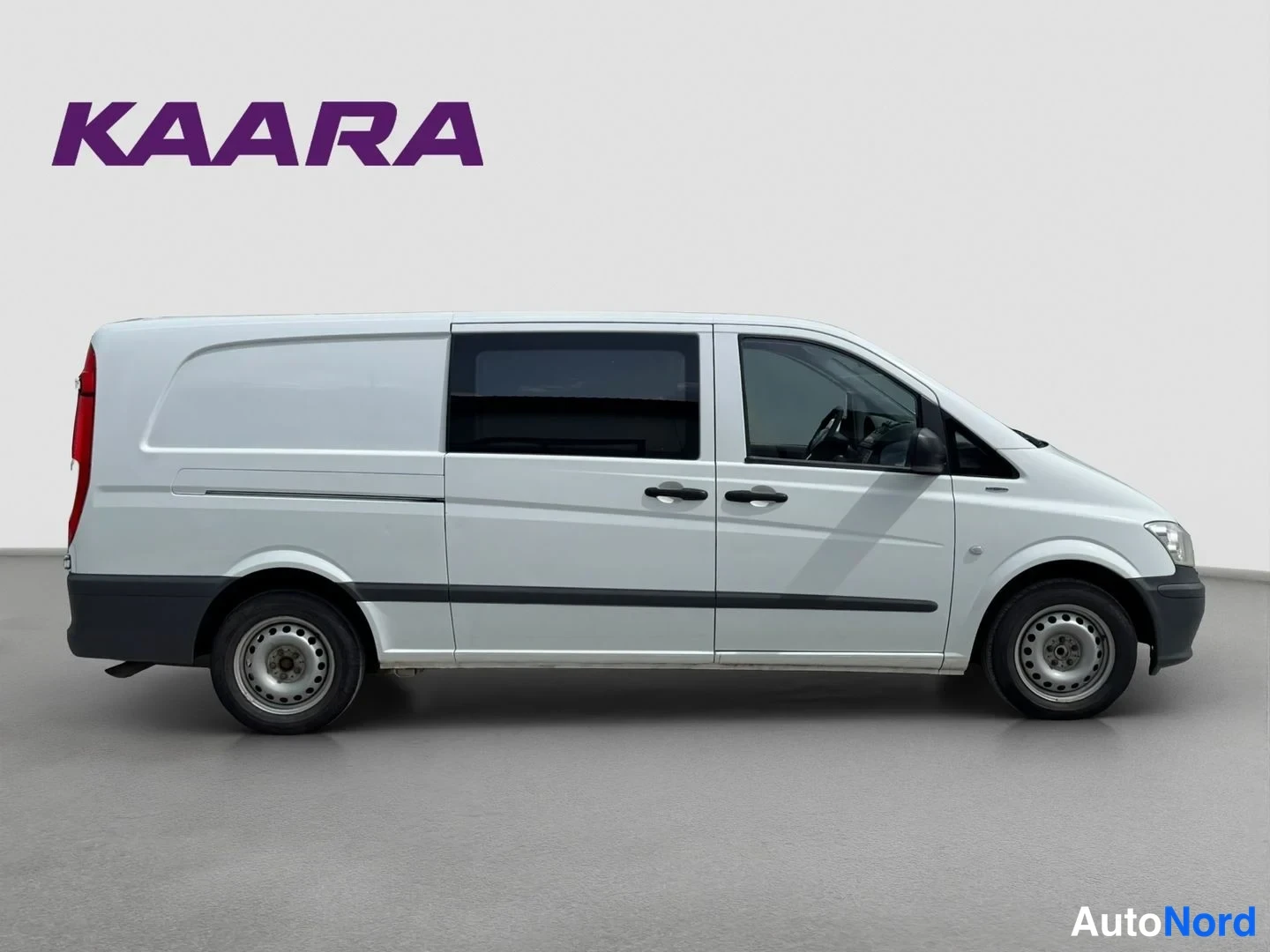 Sivulta: Valkoisen Mercedes-Benz Vito -pakettiauton sivukuva, kuljettajan puoleinen kylki, taka- ja etuovi sekä tummat sivuikkunat.