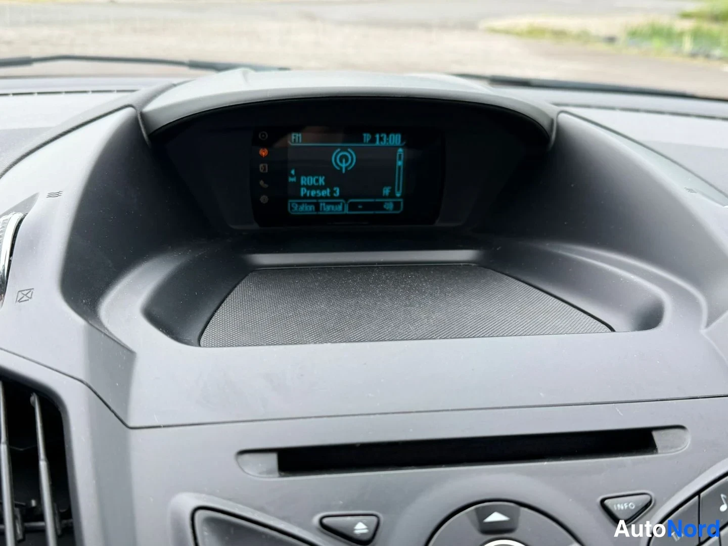 Muu: Ford Kugan kojelaudan yläosan infonäyttö, jossa radio-asetukset 'FM ROCK Preset 3' ja taajuus 13:00.