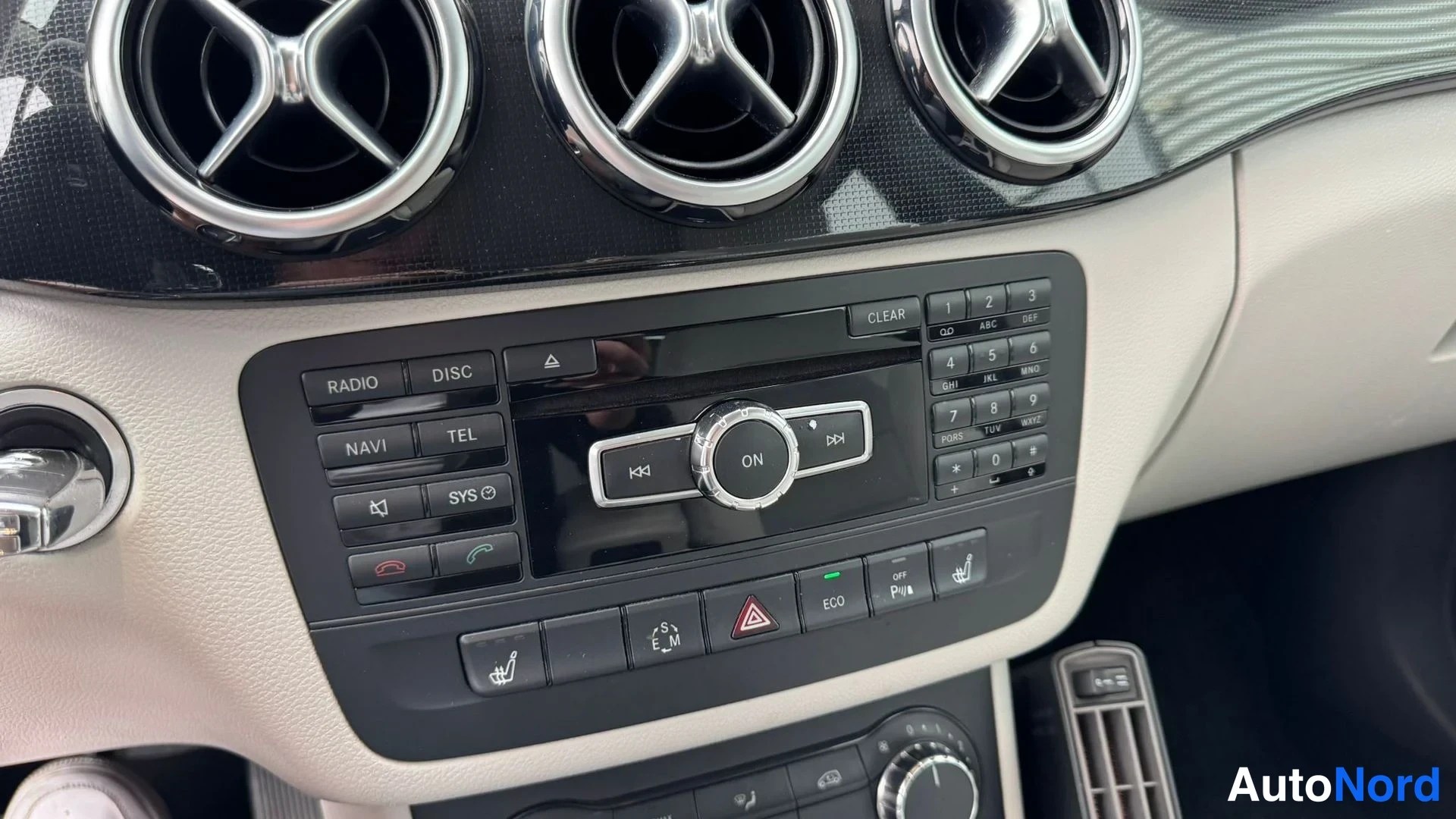 Muu: Keskirokonsoli: ilmastointitekstuuri-ilmaventtiilit, Radio/Disc/Navi/Tel/Sys-napit, numeronäppäimet ja ECO/Start-Stop-painikkeet.
