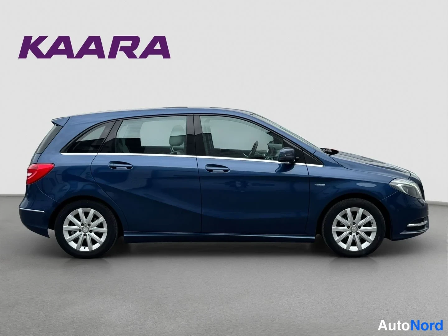 Etuviisto, nokka oikealle: Sininen Mercedes-Benz B-luokan farmarimallinen auto sivulta etukulmasta oikeaan orientoituneena.