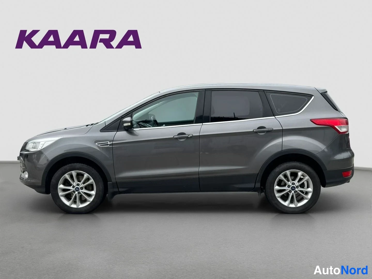 Etuviisto, nokka vasemmalle: Ford Kuga:n sivuprofiili vasemmasta etukulmasta; tummanharmaa maalaus, viisiovisen korin ja alumiinivanteiden ääriviivat.