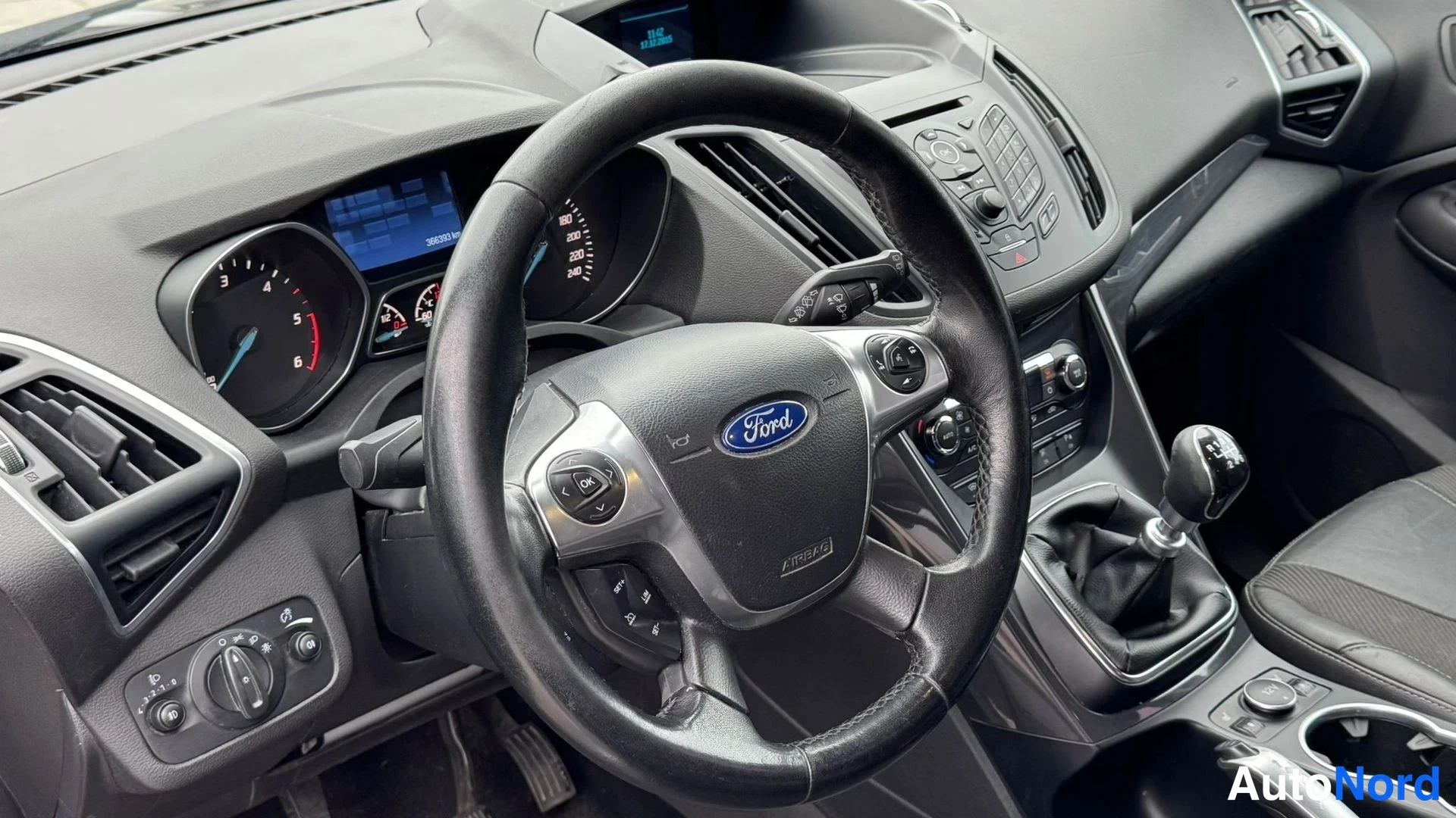 Muu: Ohjaamon kojelauta ja ohjauspyörä; Ford-logomerkitty pyörä, manuaali vaihdelaatikon vaihdekeppi ja mittaristo näkyvät.