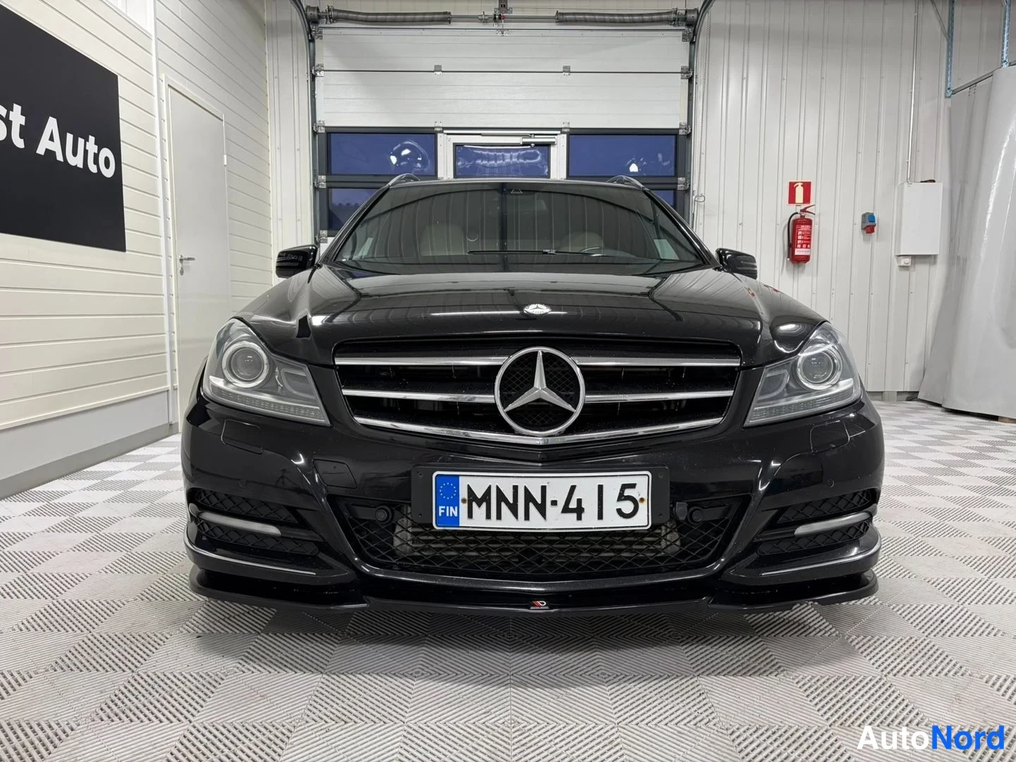 Edestä: Mercedes-Benz mustan auton etupää suoraan edestä, rekisteritunnus