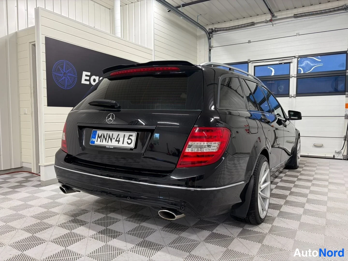 Takaviisto: Mercedes-Benz farmari mustana takakulmasta, rekisteritunnus